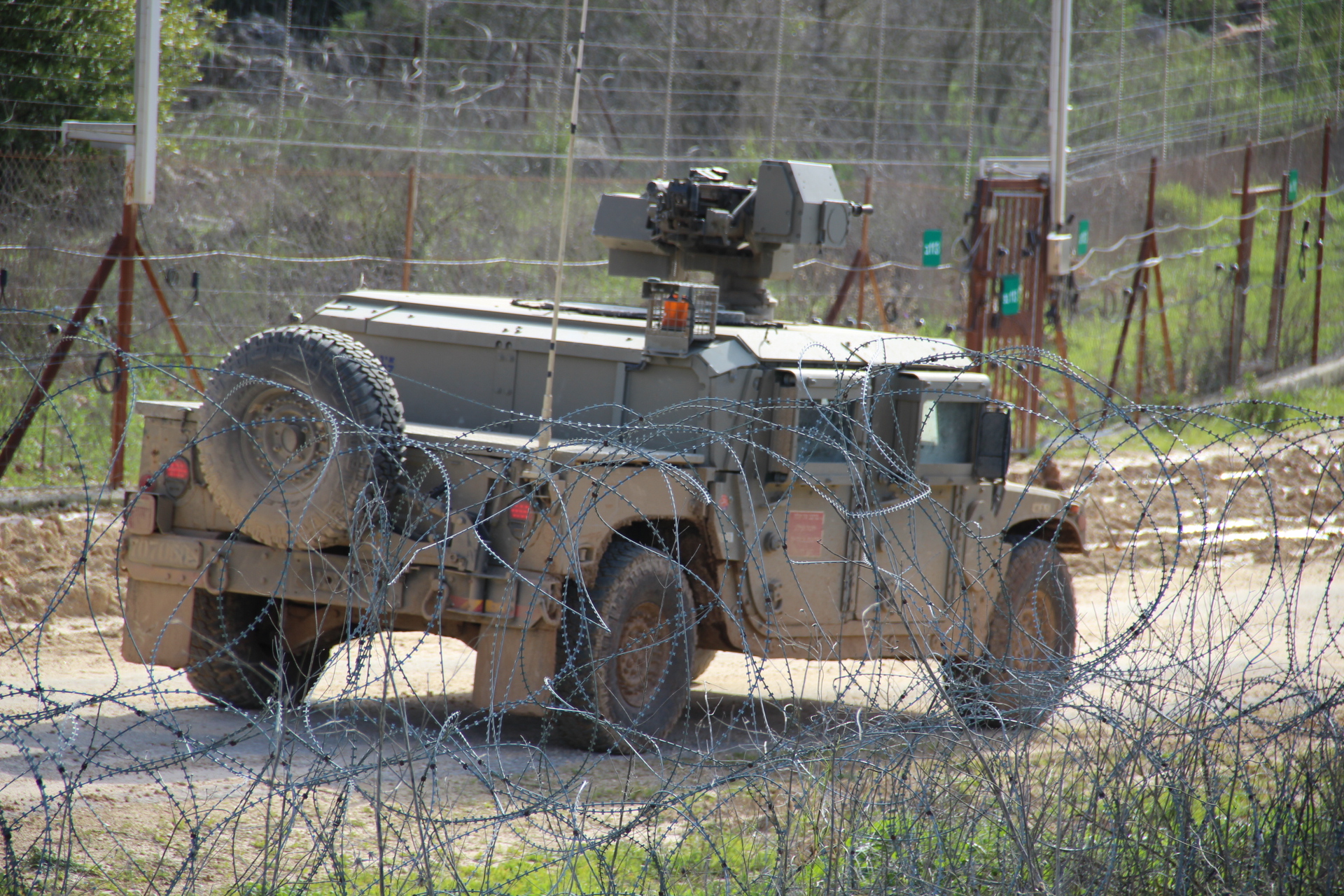 An IDF armored patrol vehicle behind concertina wire on patrol along the Israel-Lebanon border security barrier, western sector of the northern frontier