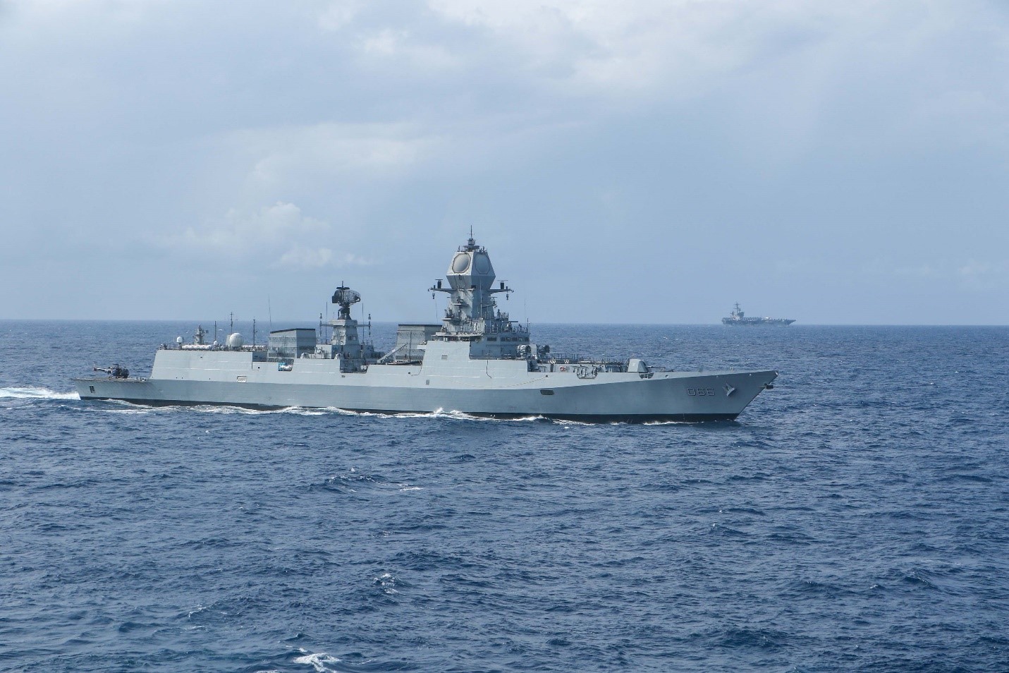 INS Visakhapatnam D66 Visakhapatnam-class stealth guided-missile destroyer conducting joint exercises in the Indian Ocean, USS Theodore Roosevelt carrier visible in background