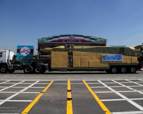 Iranian ballistic missile on transporter erector launcher at Sacred Defence Week parade, Tehran 2015, flanked by IRGC banners
