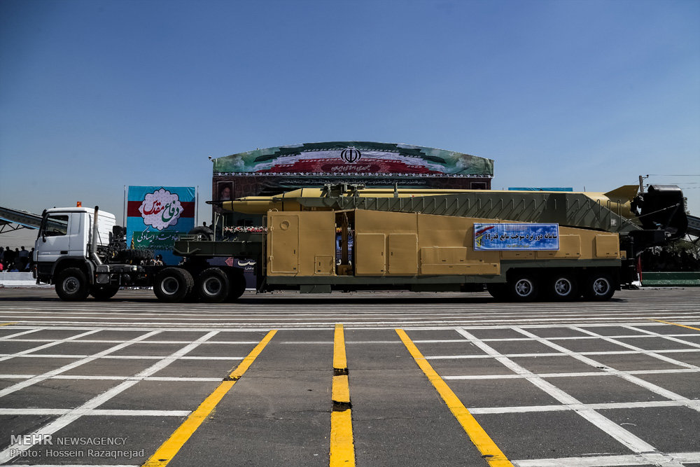Iranian ballistic missile on transporter erector launcher at Sacred Defence Week parade, Tehran 2015, flanked by IRGC banners