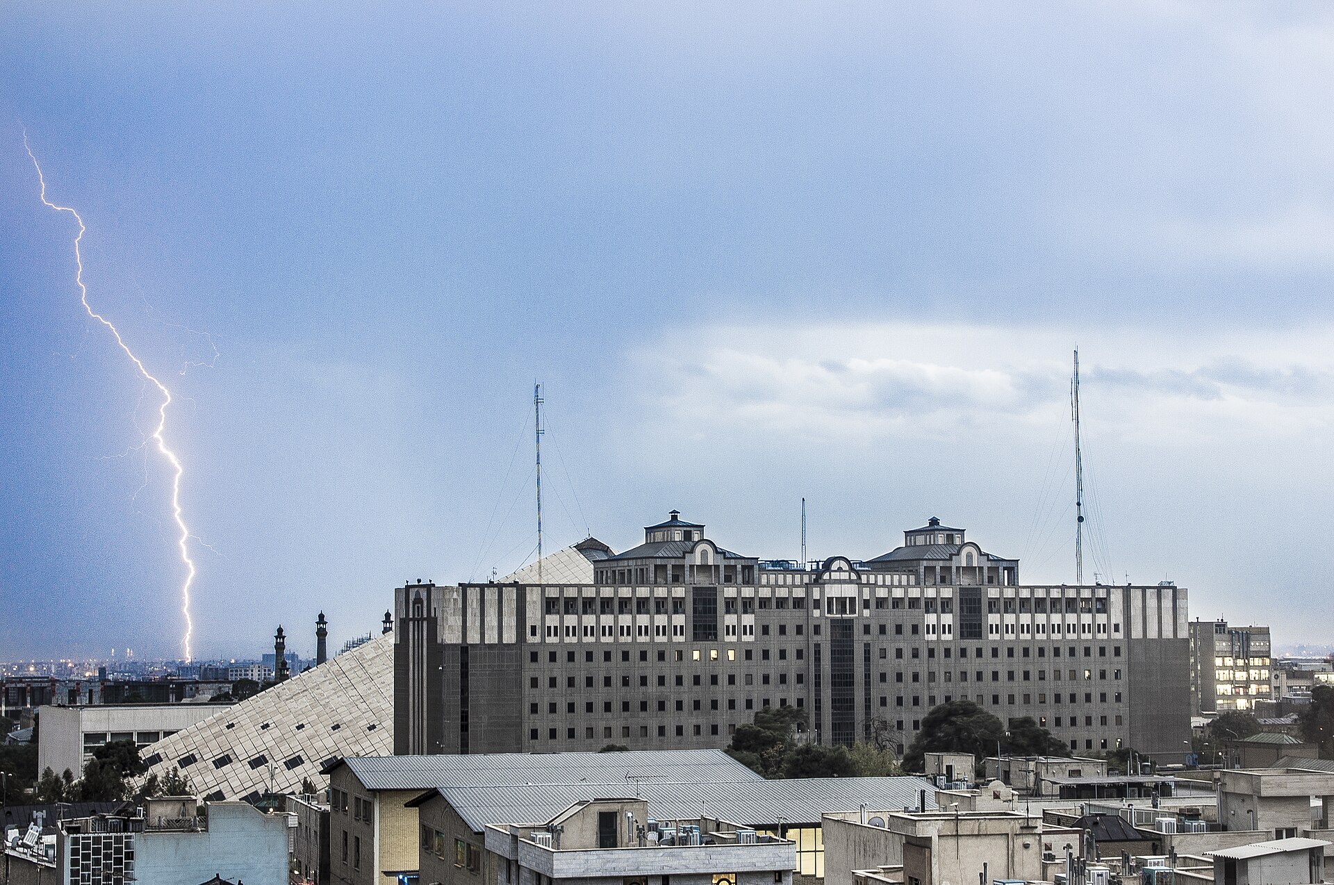Iranian Parliament building (Majlis) in Tehran during a thunderstorm, seat of the Islamic Consultative Assembly that codified the Hormuz toll legislation on March 31, 2026