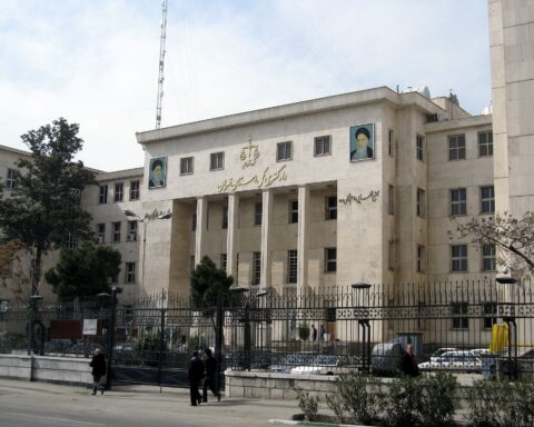 Iranian government building in Tehran displaying portraits of Supreme Leader Khomeini and Khamenei on its facade