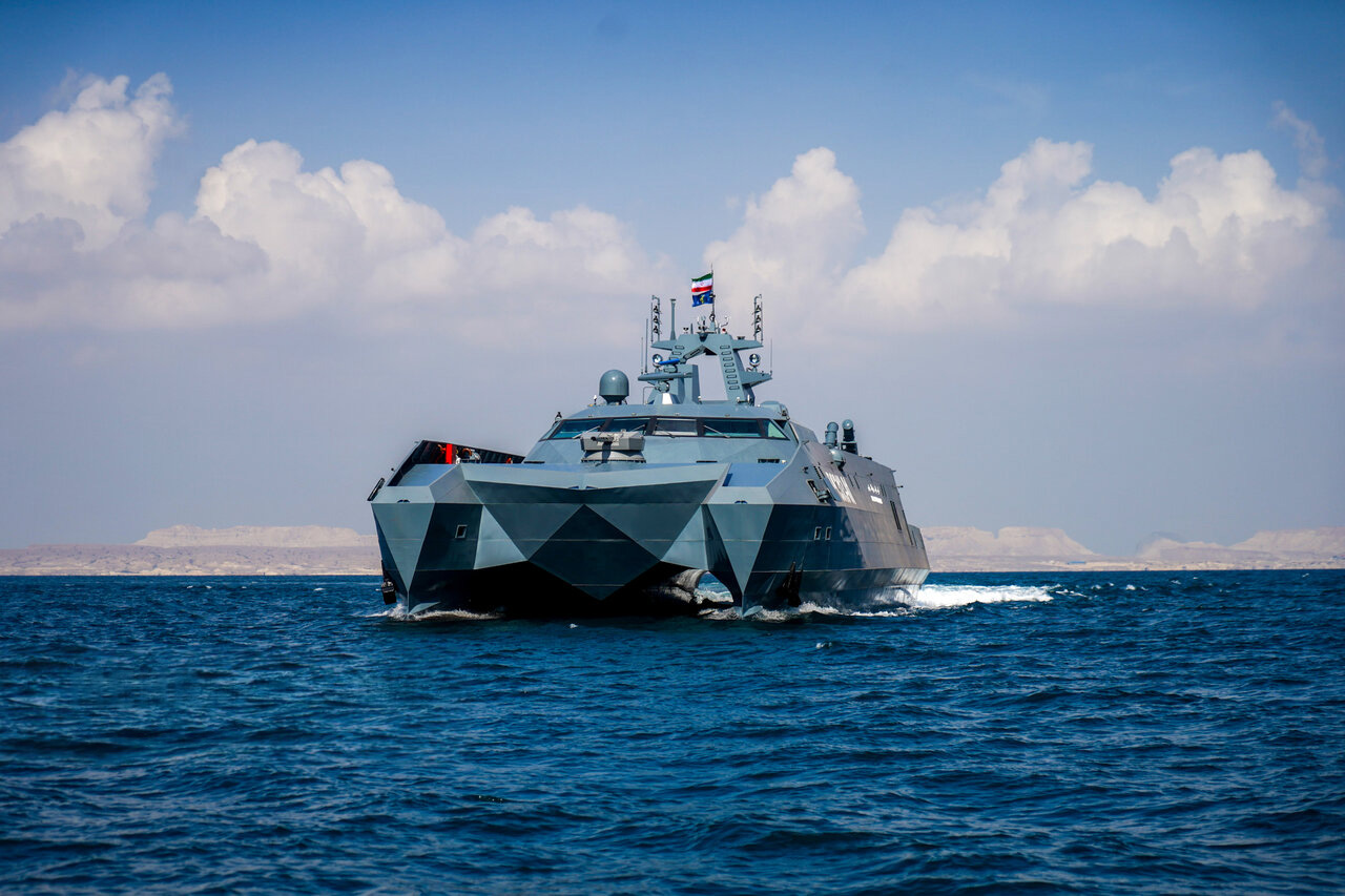 IRGC Navy stealth catamaran warship IRIS Abu Mahdi Al-Muhandis underway in the Persian Gulf with island coastline visible in background, January 2024 commissioning