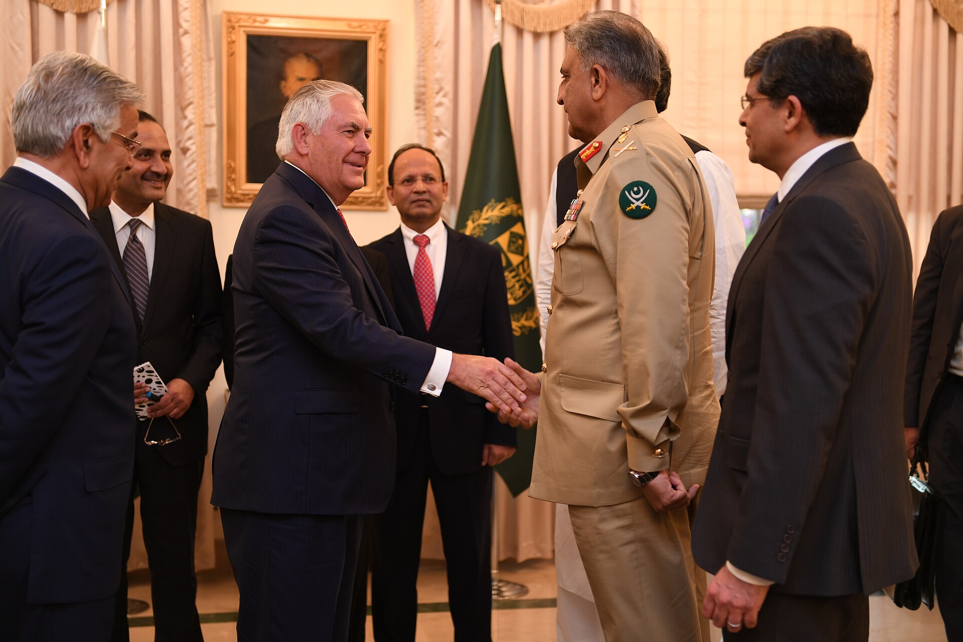 US Secretary of State Rex Tillerson shakes hands with Pakistani Army Chief General Bajwa at the Prime Minister House in Islamabad, Pakistan flag visible