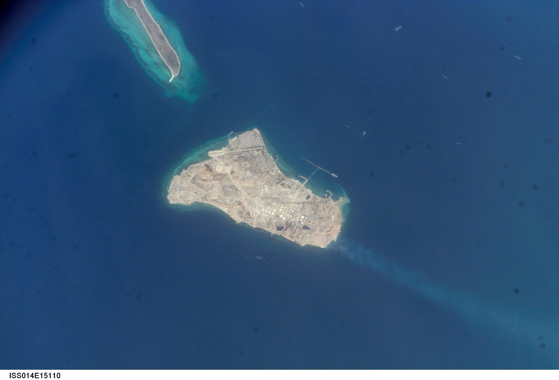 Kharg Island oil terminal, Persian Gulf, photographed from the International Space Station during Expedition 14. Oil storage tanks and loading piers are visible; the island handles approximately 94% of Iran crude exports.