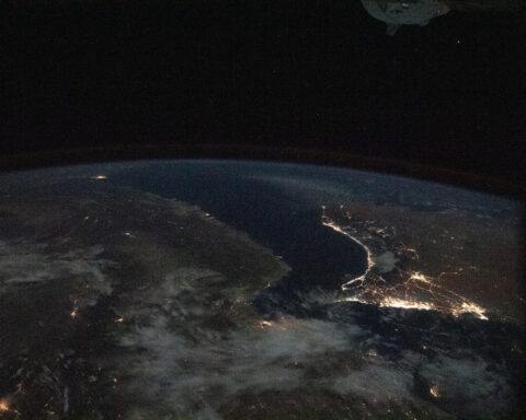 The Persian Gulf and Gulf of Oman photographed from the International Space Station at night, showing city lights along the Arabian Peninsula and Iranian coast flanking the Strait of Hormuz chokepoint. Photo: NASA / Public Domain