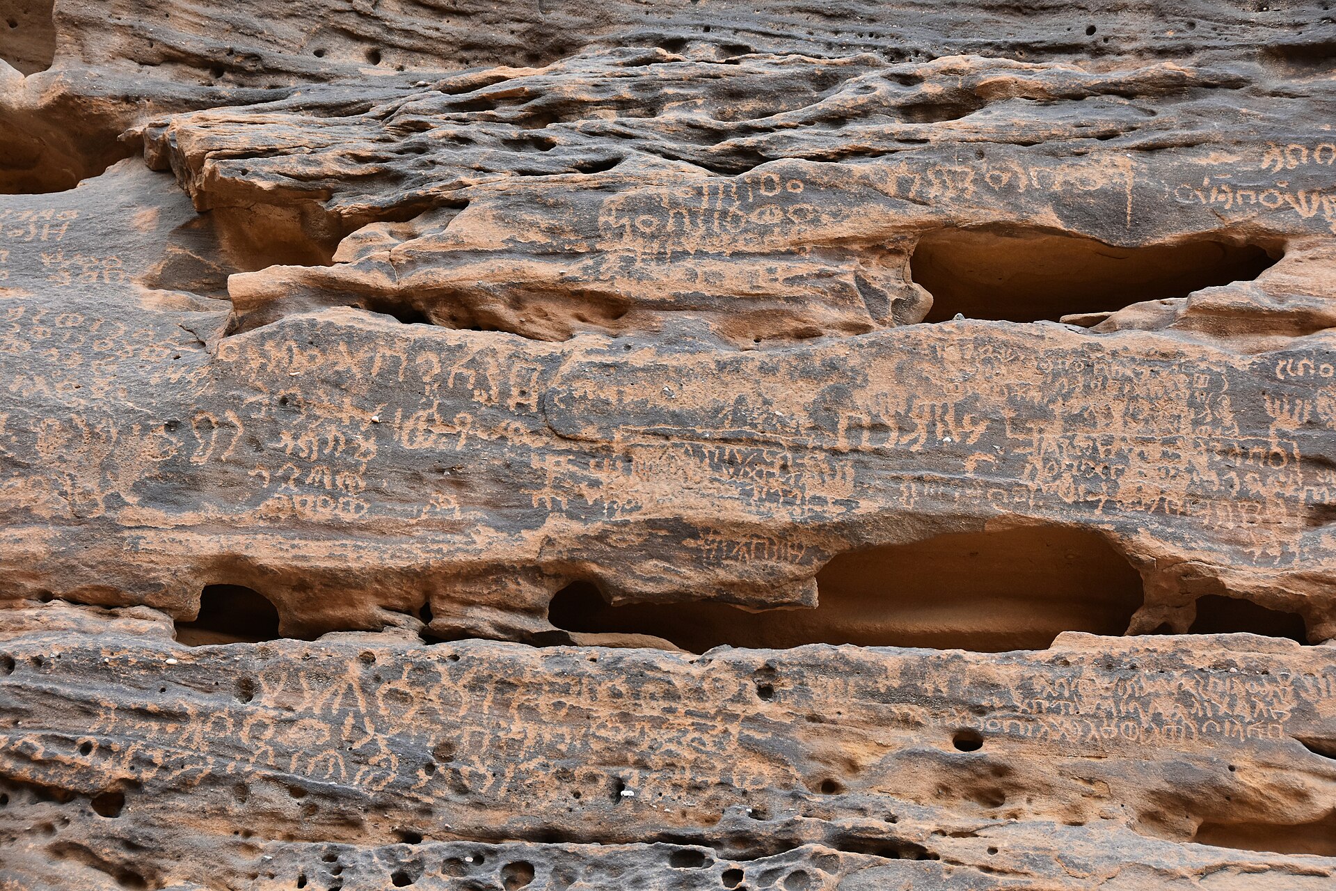 Close-up of ancient Dadanitic script carved into sandstone at Jabal Ikmah, AlUla
