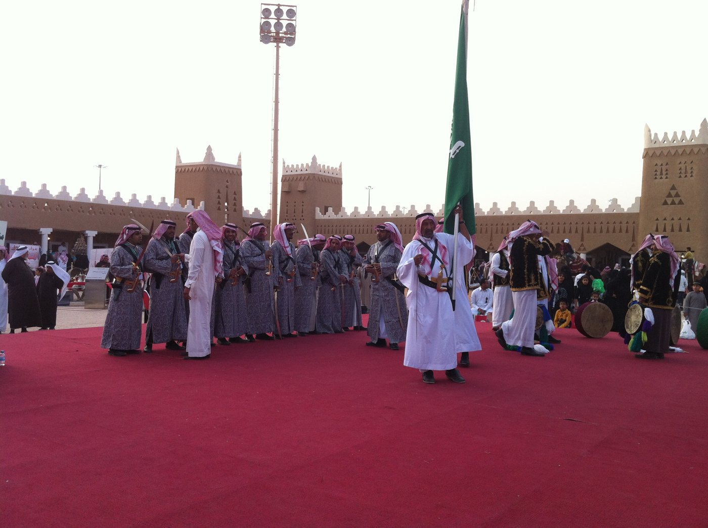 Performers in traditional dress carrying the Saudi flag and drums at the Janadriyah National Heritage Festival