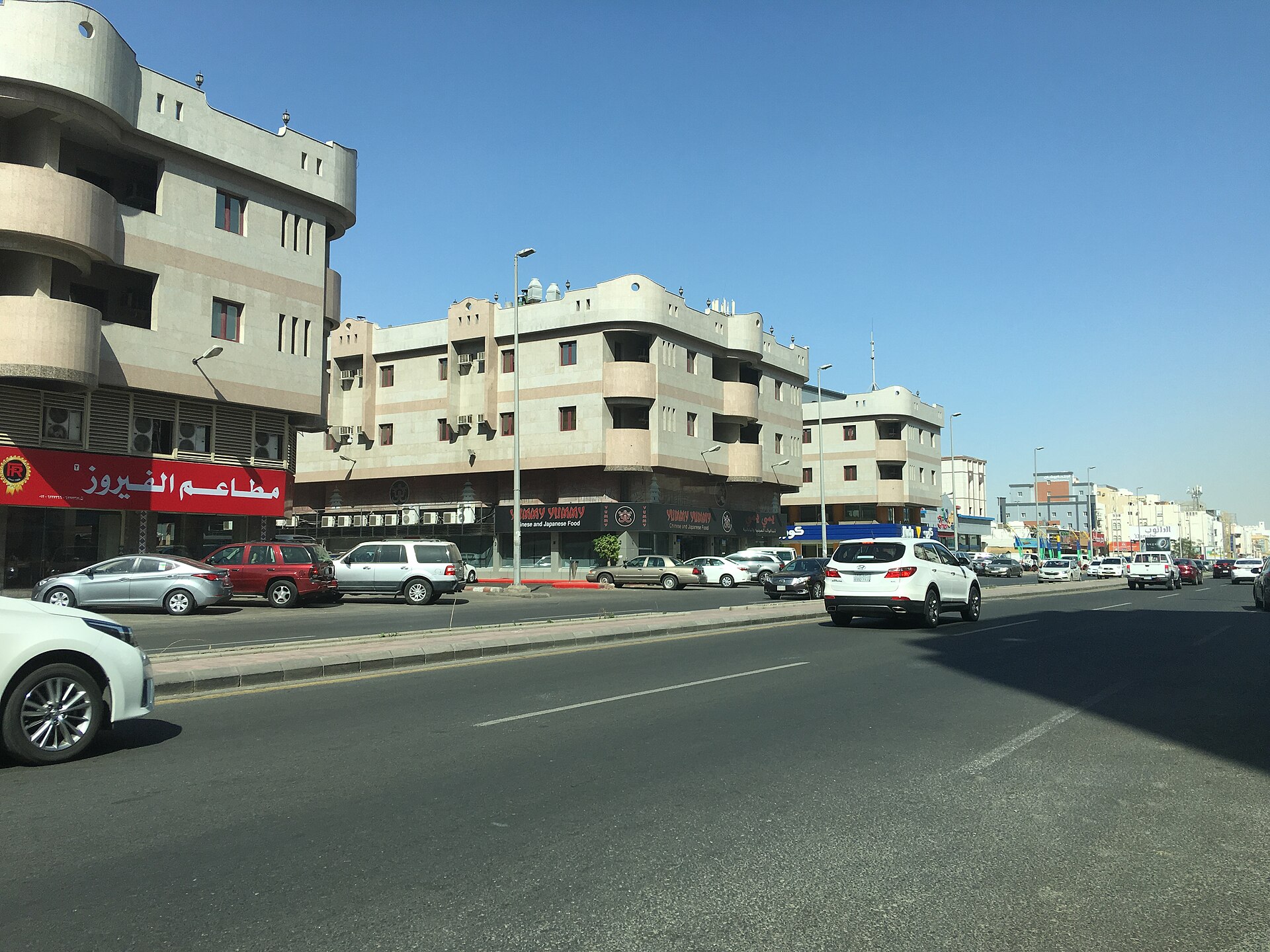 Street view of Jeddah city centre with buildings, shops, and traffic