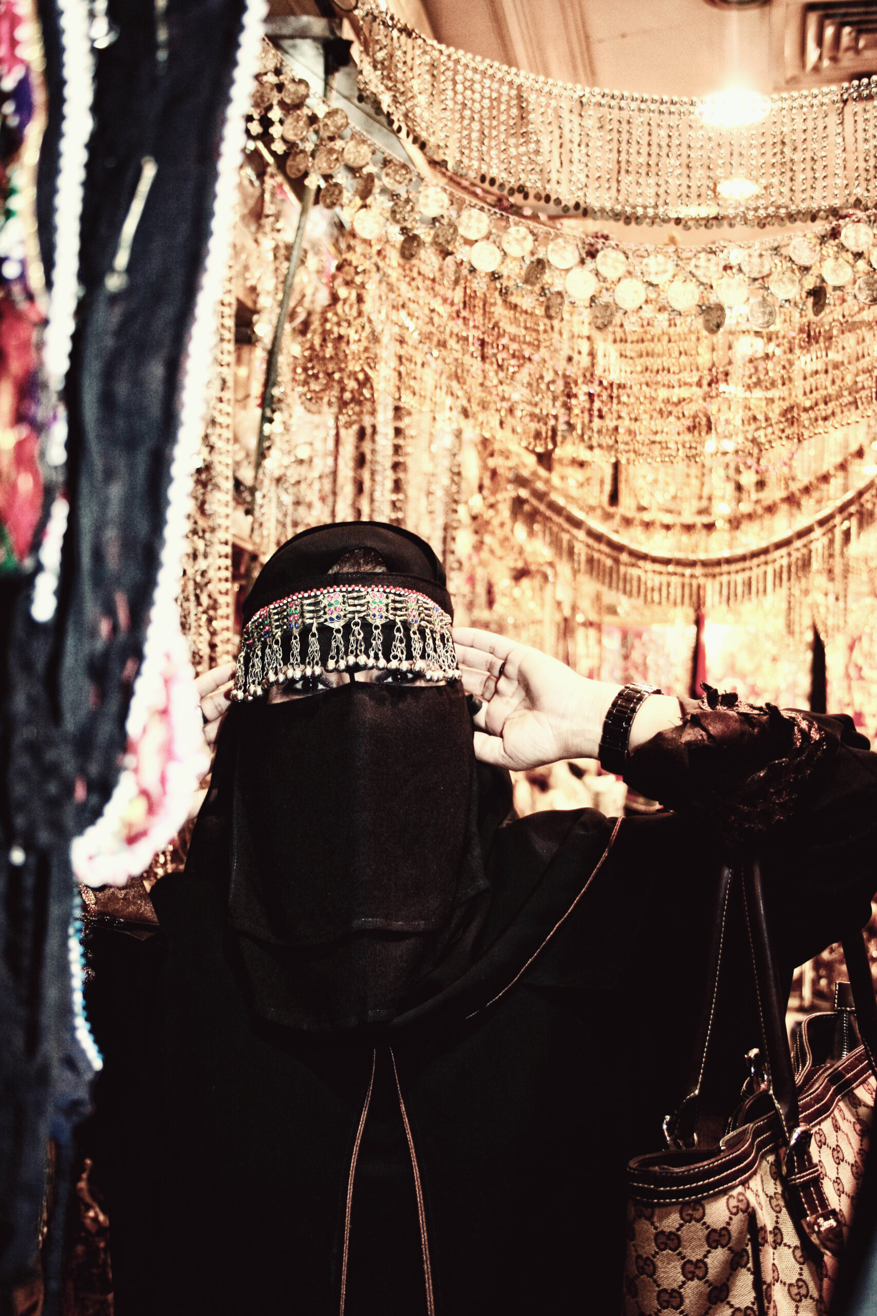 A woman tries on traditional silver jewellery in a gold and silver souk in downtown Jeddah, Saudi Arabia