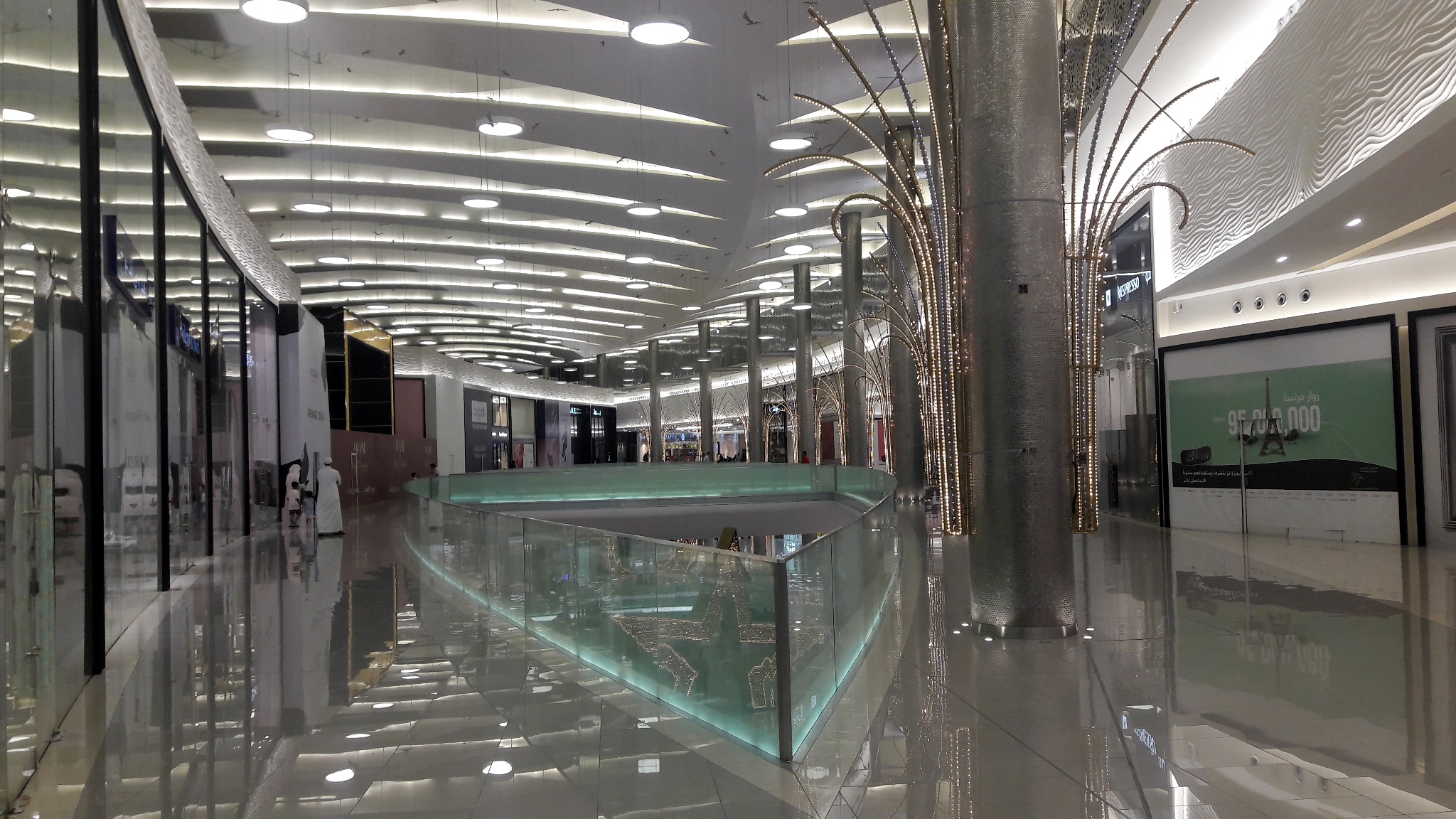 Interior of Mall of Arabia Jeddah showing modern architecture with decorative tree-shaped columns and reflective floors