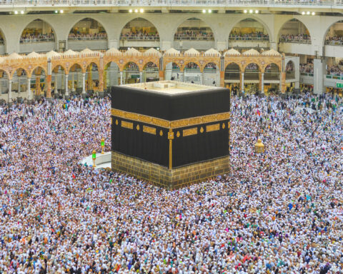 Aerial view of hundreds of thousands of pilgrims in white ihram performing tawaf around the Kaaba at the Grand Mosque in Mecca during Hajj — the world's largest annual human gathering