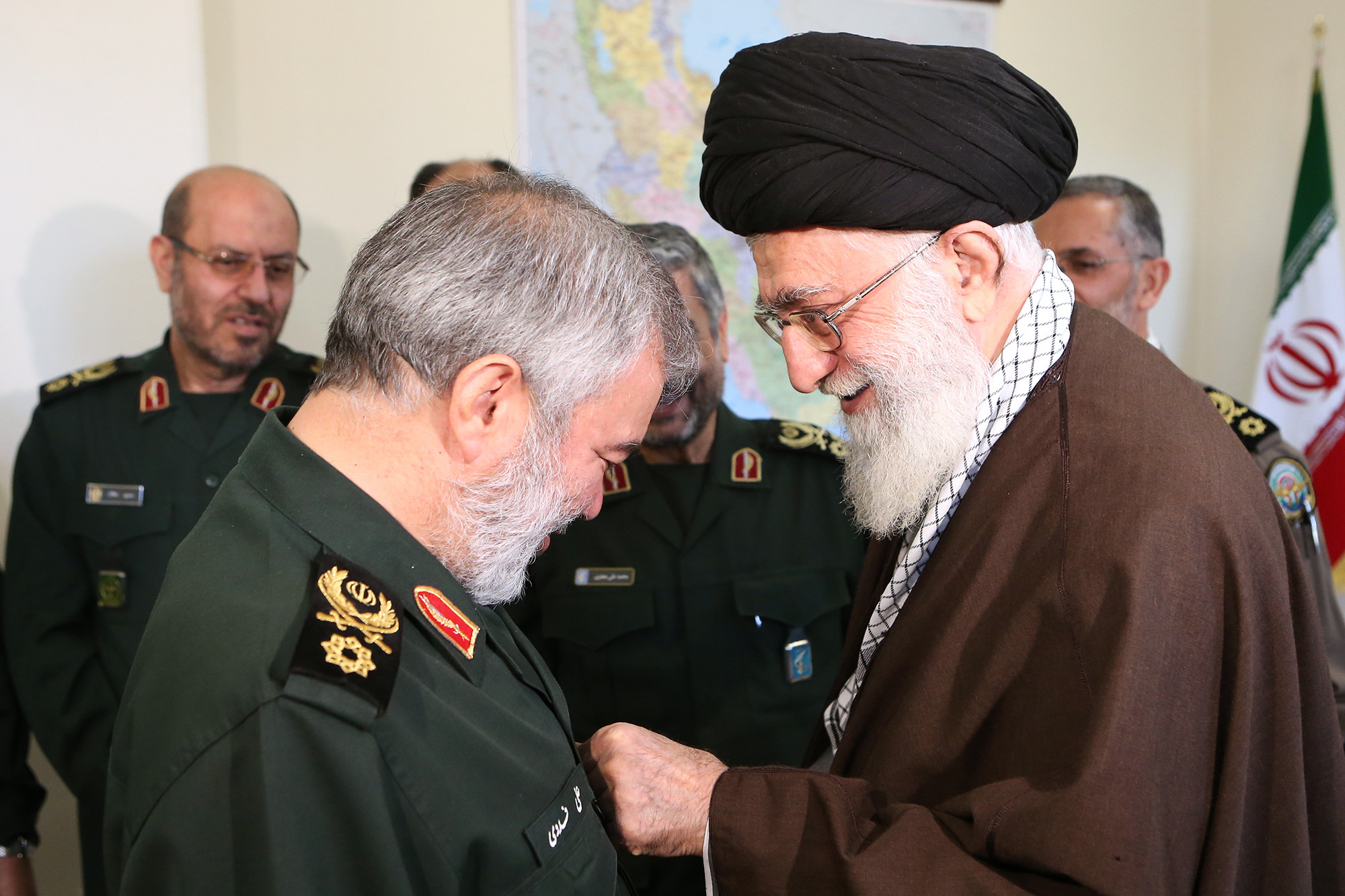 Supreme Leader Khamenei decorates IRGC Commander Ali Fadavi with the Order of Conquest in January 2016. Under Article 176 of Iran's constitution, all SNSC decisions require Khamenei's confirmation — a process now stalled by his reported incapacitation.