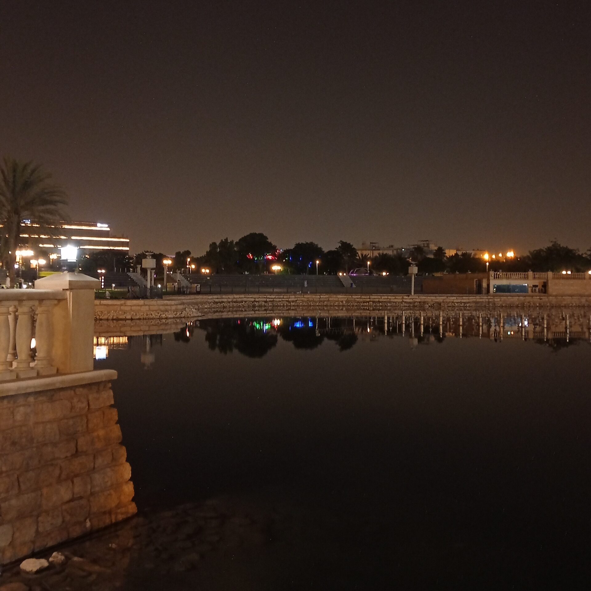 The artificial lake at King Abdullah Park in Riyadh at night with reflections of coloured lights on the water