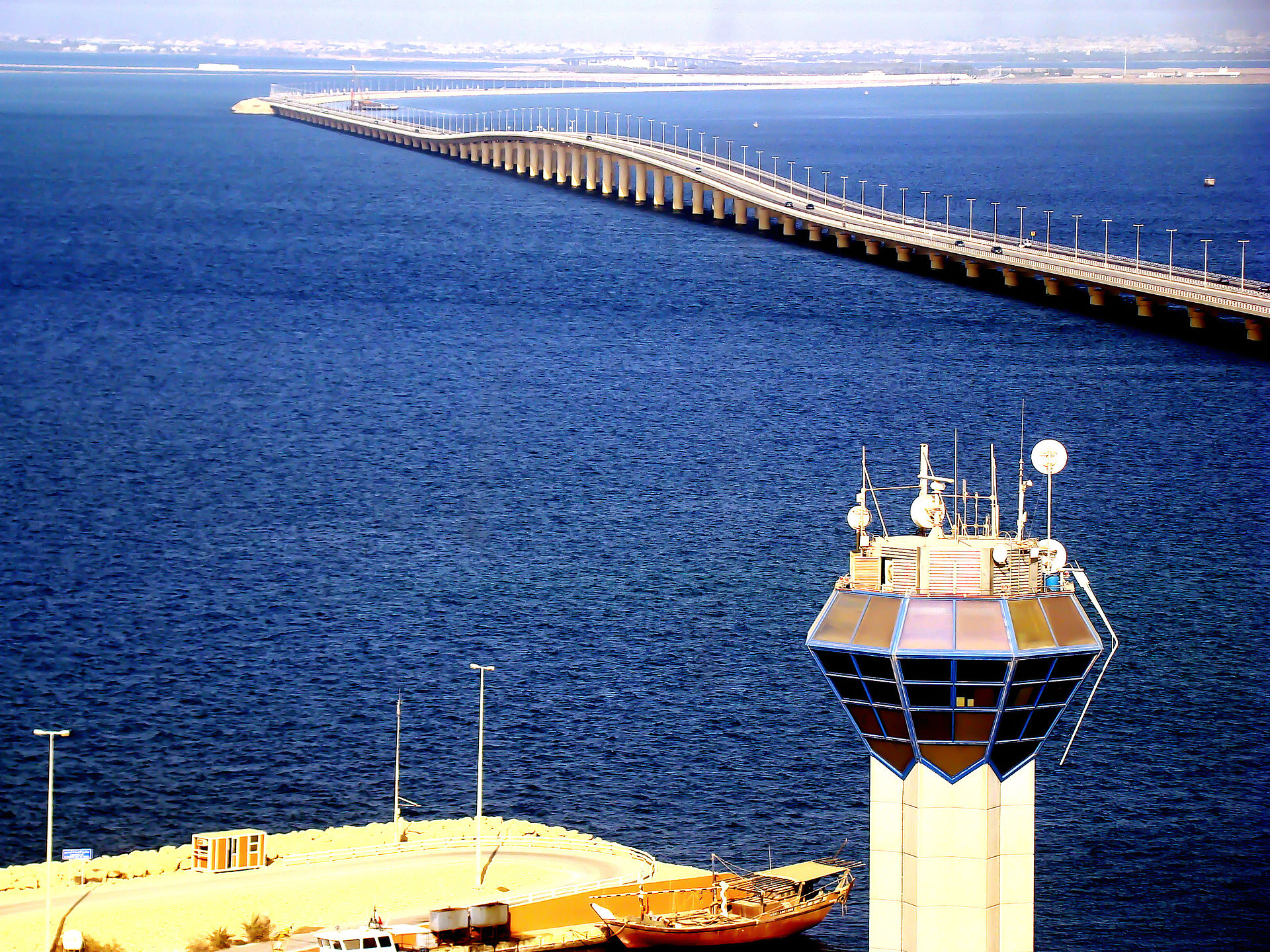 King Fahd Causeway extending across deep blue Gulf waters with radar control tower in foreground, viewed from elevated position on the Saudi Arabia side