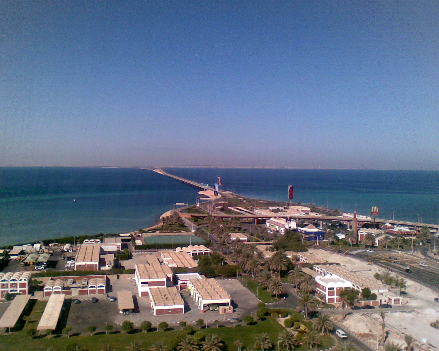 Aerial view of the King Fahd Causeway stretching across the turquoise Arabian Gulf from Saudi Arabia toward Bahrain