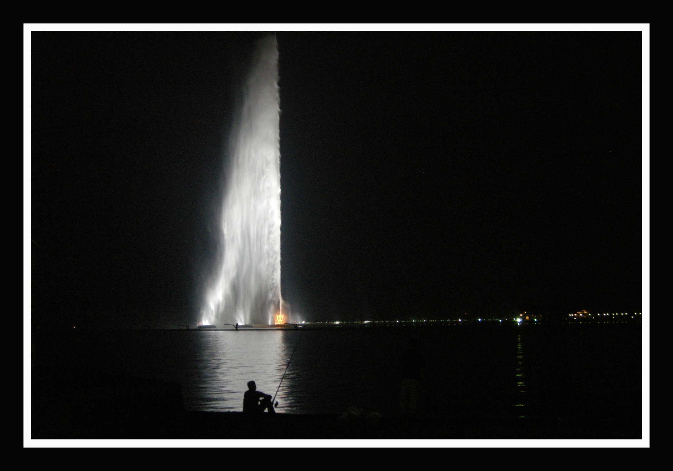 King Fahd Fountain illuminated at night, shooting water high into the dark sky over the Red Sea in Jeddah