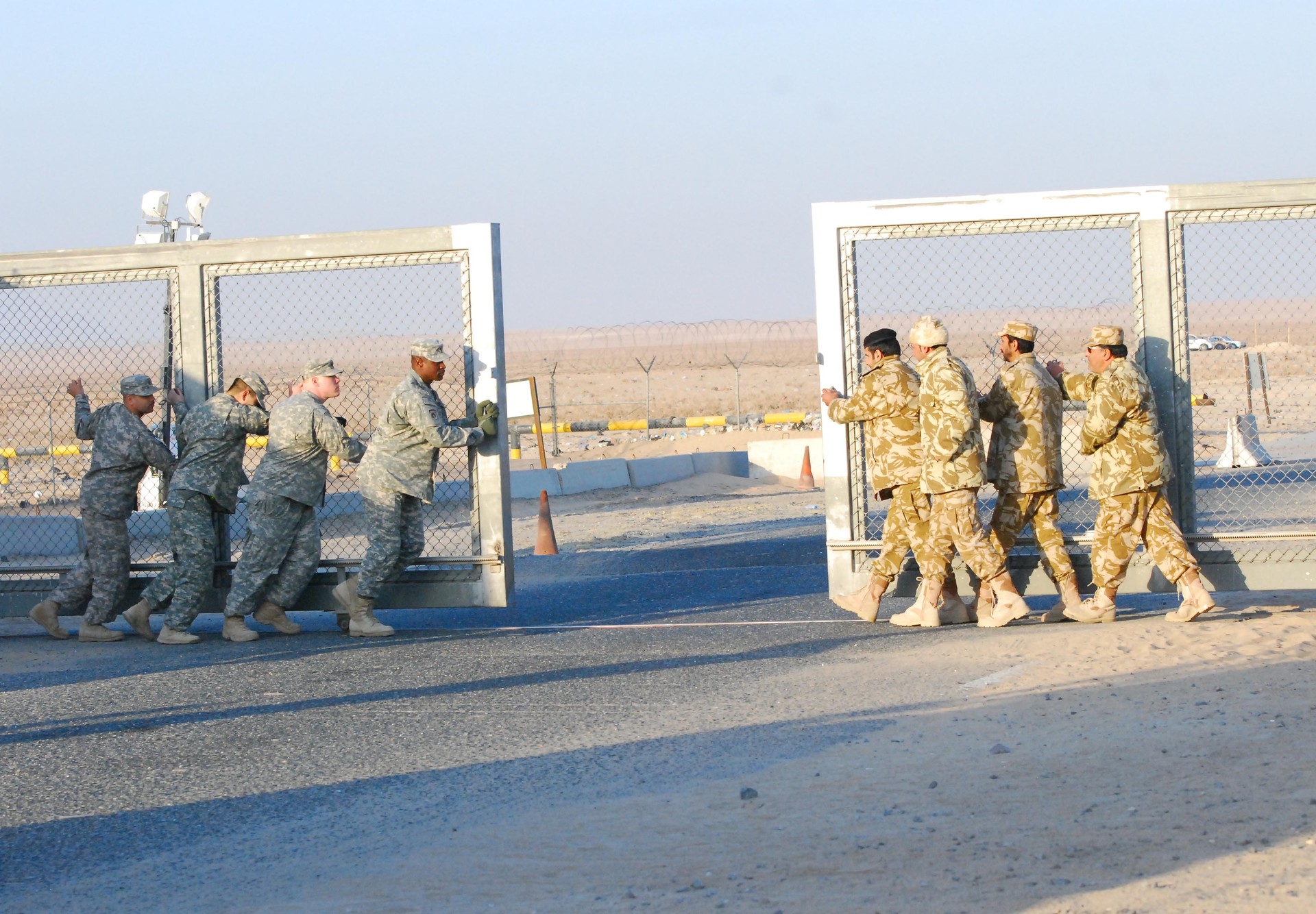 US and Kuwaiti soldiers closing the Khabari Crossing border gate at the Iraq-Kuwait frontier, December 2011