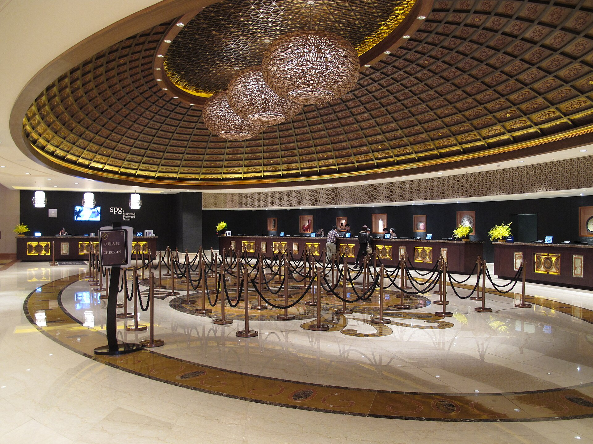 Empty luxury hotel lobby check-in area with queue barriers and no guests, representing the tourism collapse during the Iran war