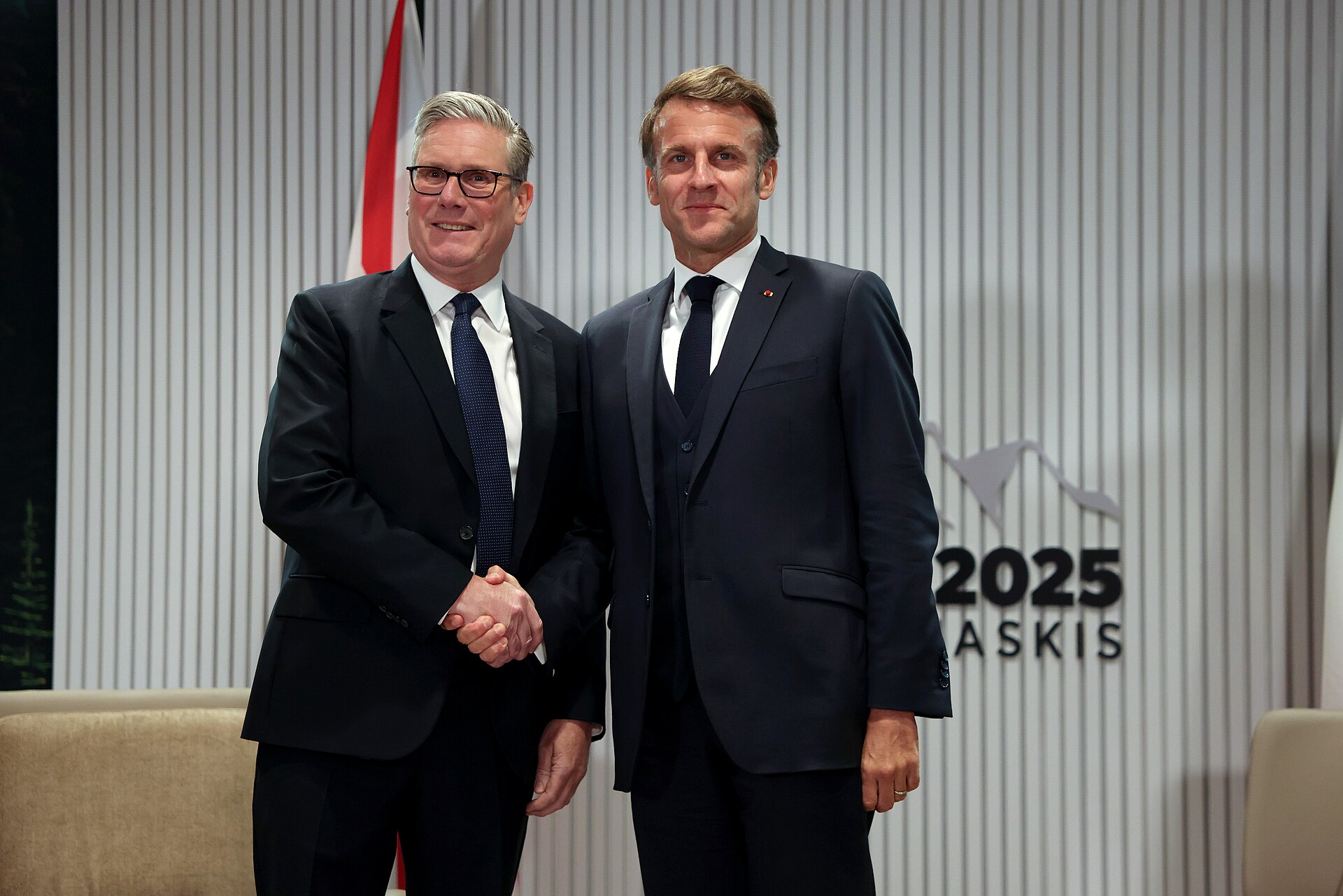 UK Prime Minister Keir Starmer and French President Emmanuel Macron shaking hands at the G7 Kananaskis summit, 2025 — the two leaders who co-hosted the April 17, 2026 Paris Hormuz coalition summit
