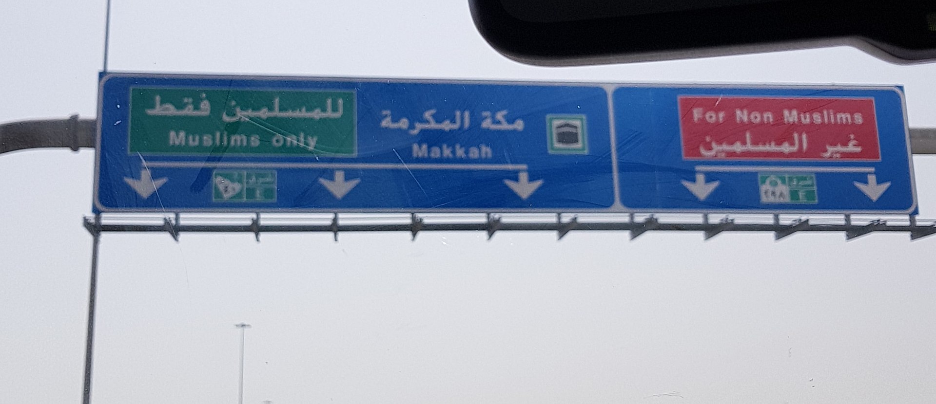 Highway sign near Makkah showing separate lanes for Muslims only and non-Muslims