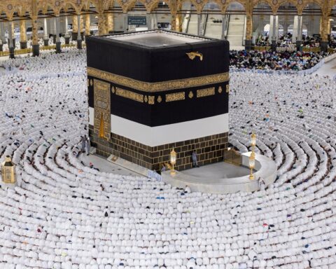 Pilgrims in white ihram garments arranged in concentric circles around the Kaaba inside the Grand Mosque of Mecca during Hajj 2025