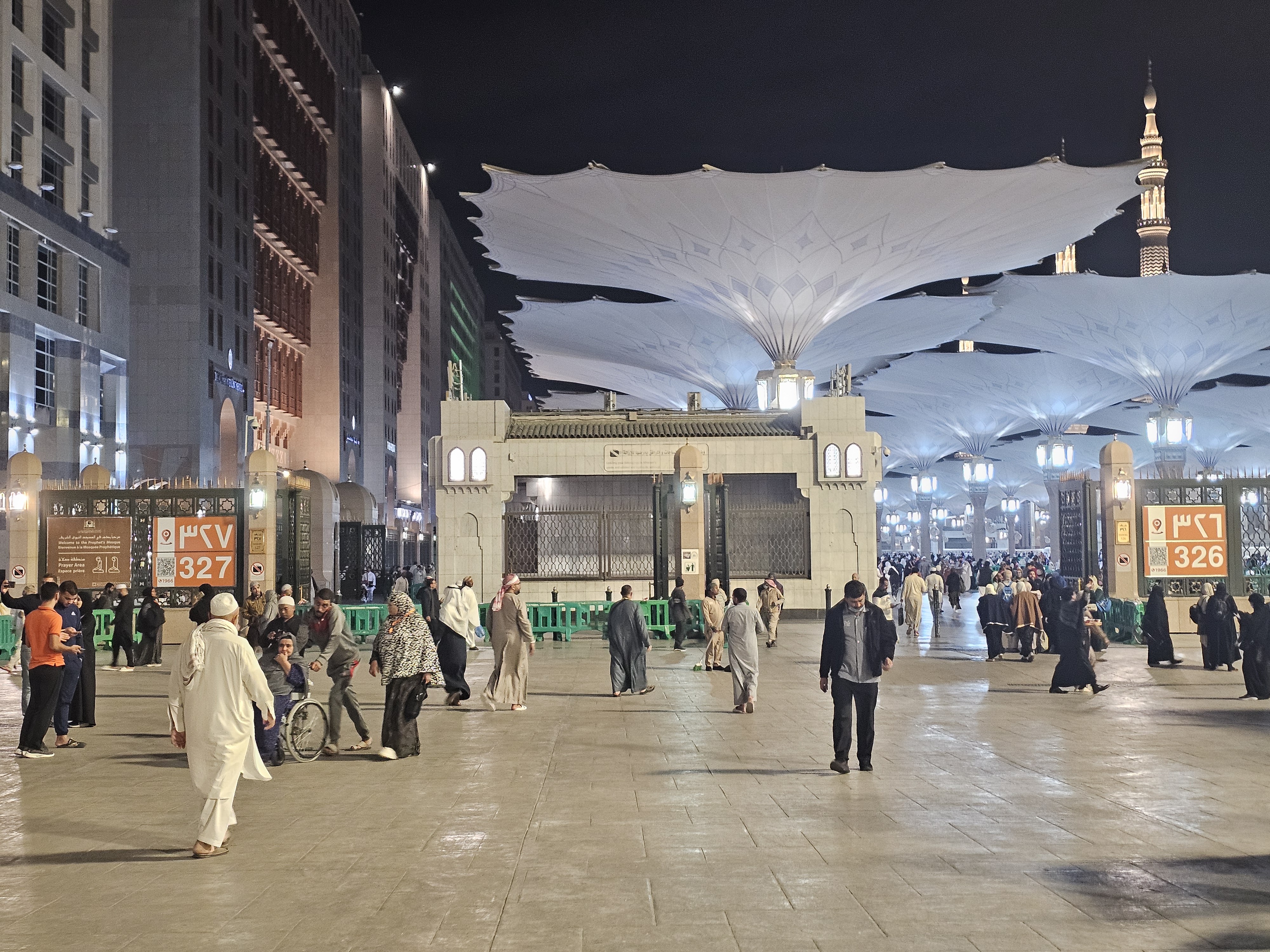 Masjid al-Nabawi at night with illuminated retractable umbrella canopies