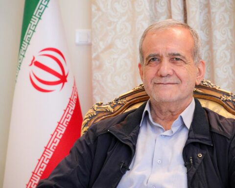 Iranian President Masoud Pezeshkian during a formal interview in 2024, seated with the Iranian flag visible behind him