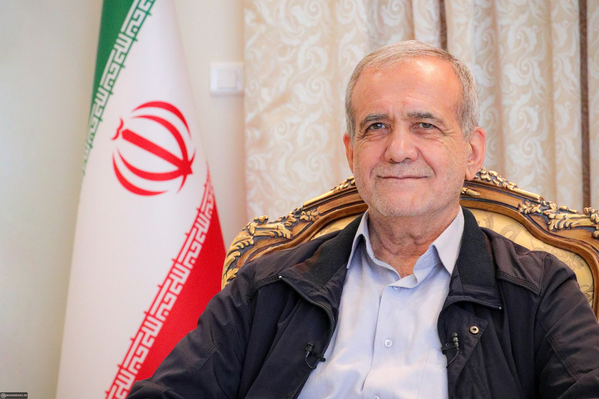 Iranian President Masoud Pezeshkian during a formal interview in 2024, seated with the Iranian flag visible behind him