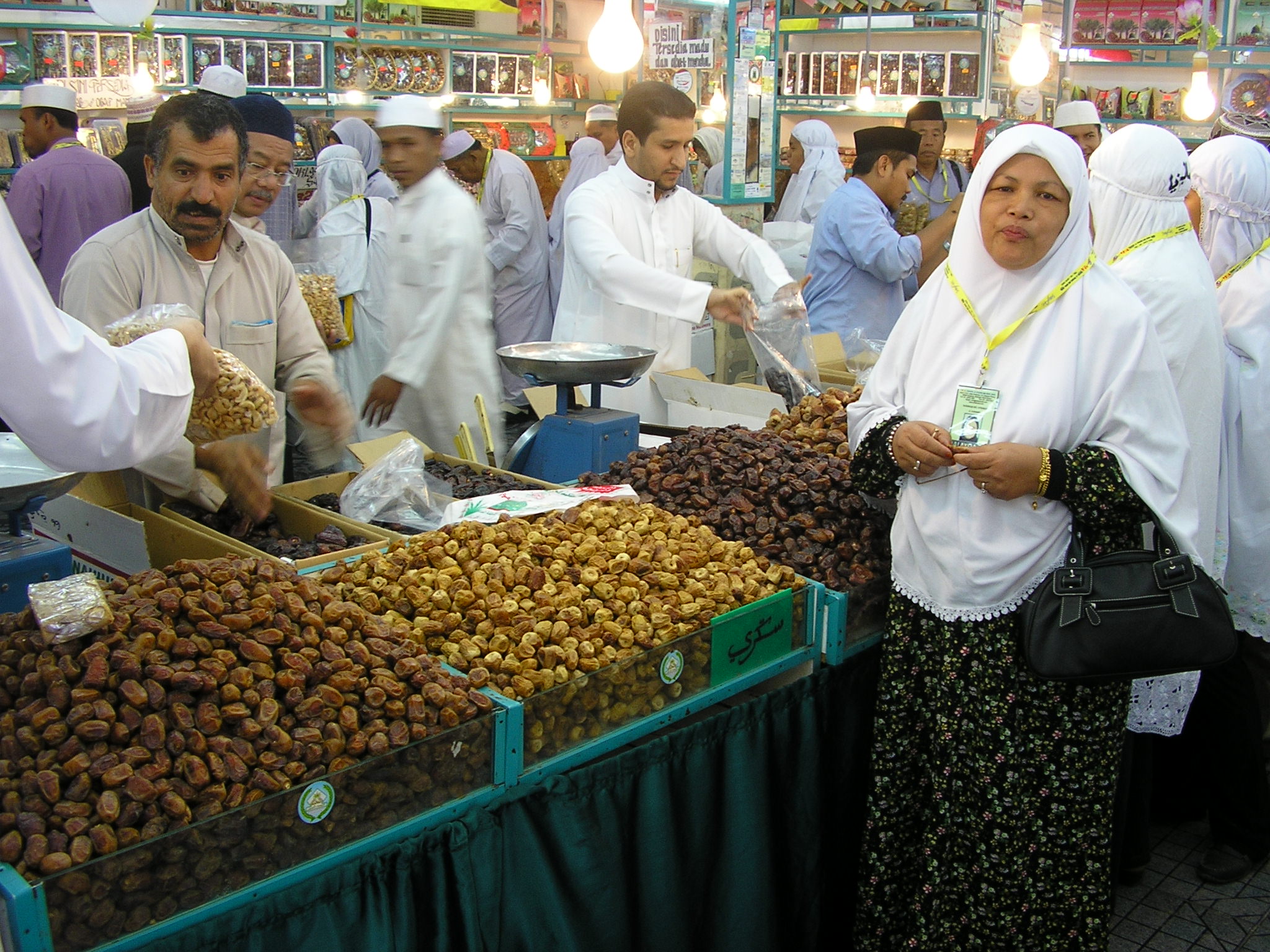 Vendors selling various date varieties at a bustling market in Madinah, Saudi Arabia