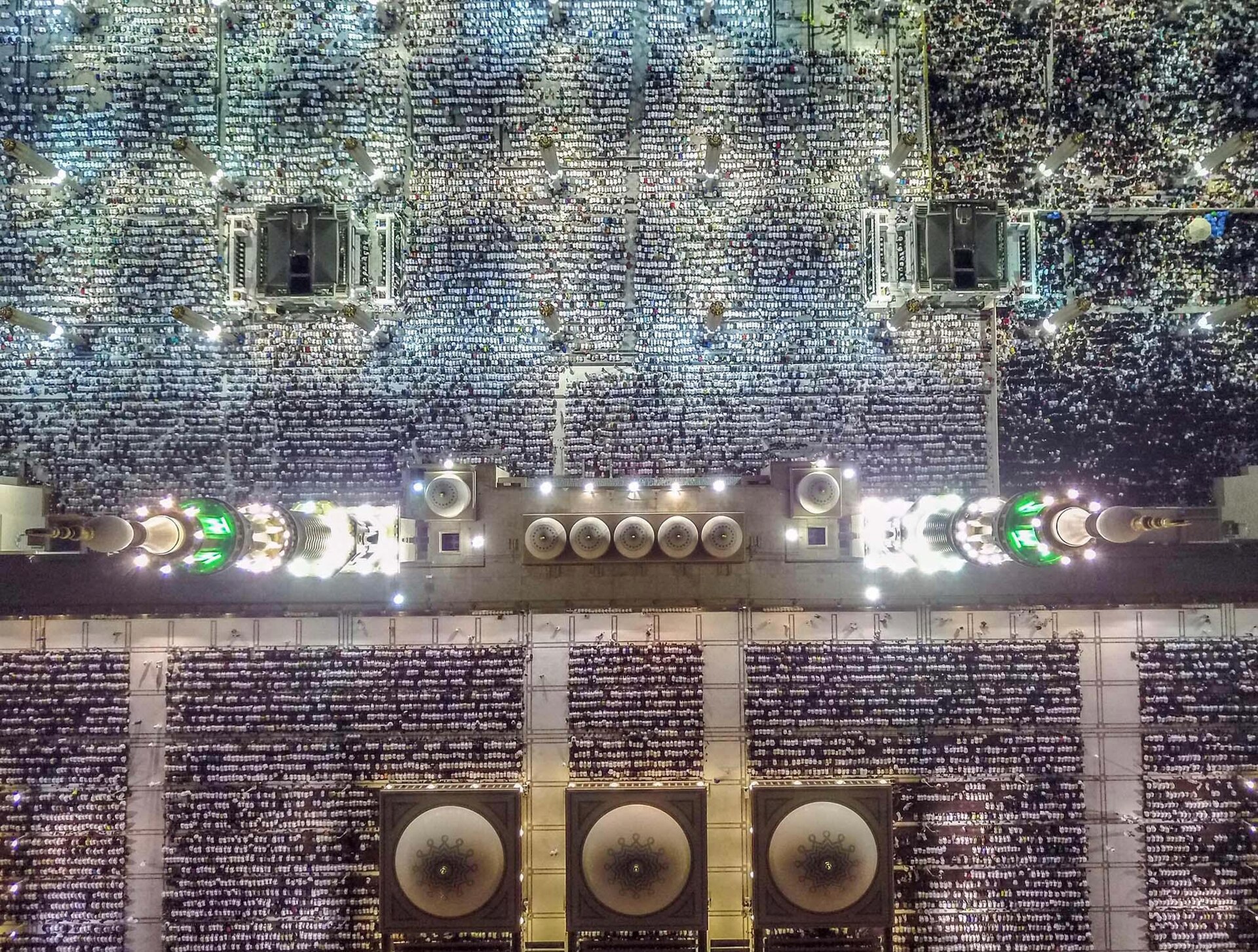 Aerial night view of the Prophet's Mosque (Masjid al-Nabawi) in Medina packed with worshippers — one of the two holy sites Saudi Arabia is now defending with its dwindling Patriot interceptor stockpile ahead of Hajj 2026. Photo: Unknown / CC BY-SA 4.0