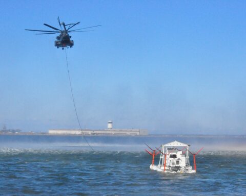 MH-53E Sea Dragon helicopter towing MK-105 mine countermeasures sweep sled over water, US Navy HM-14 practice operation