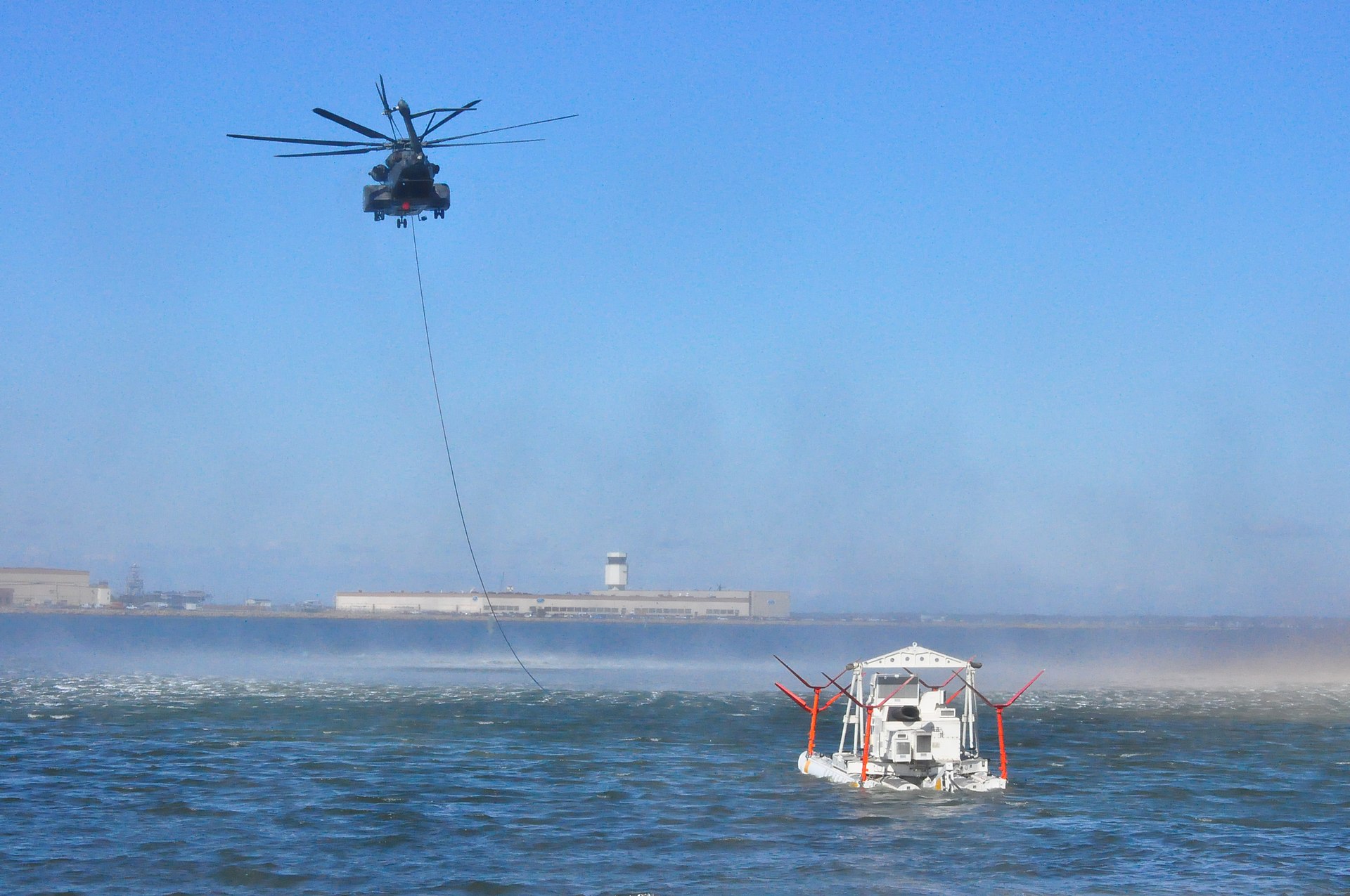 MH-53E Sea Dragon helicopter towing MK-105 mine countermeasures sweep sled over water, US Navy HM-14 practice operation
