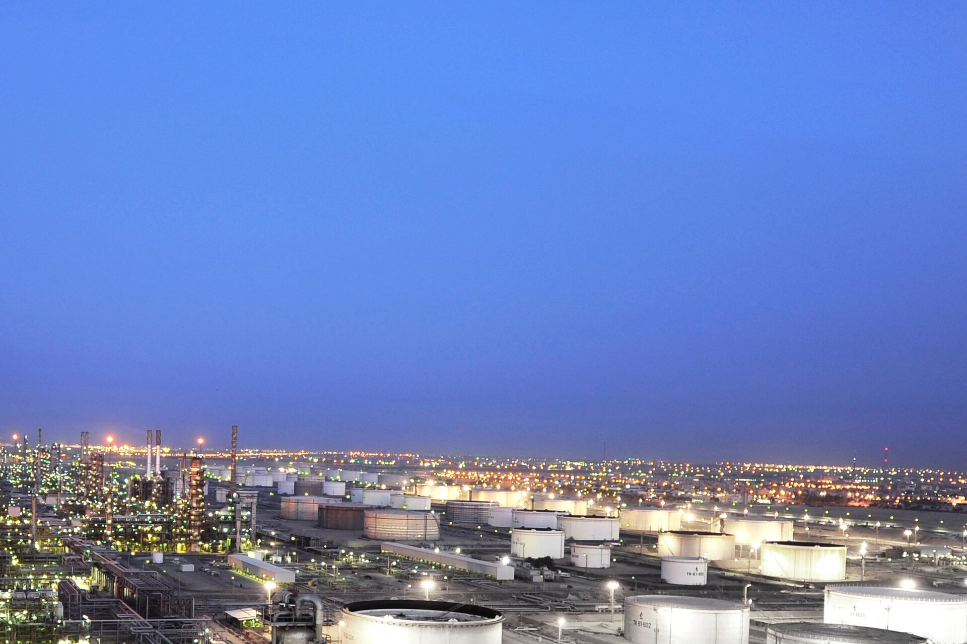 Mina Al-Ahmadi refinery complex in Kuwait at dusk, showing the sprawling network of storage tanks and processing infrastructure struck by Iranian missiles in March-April 2026