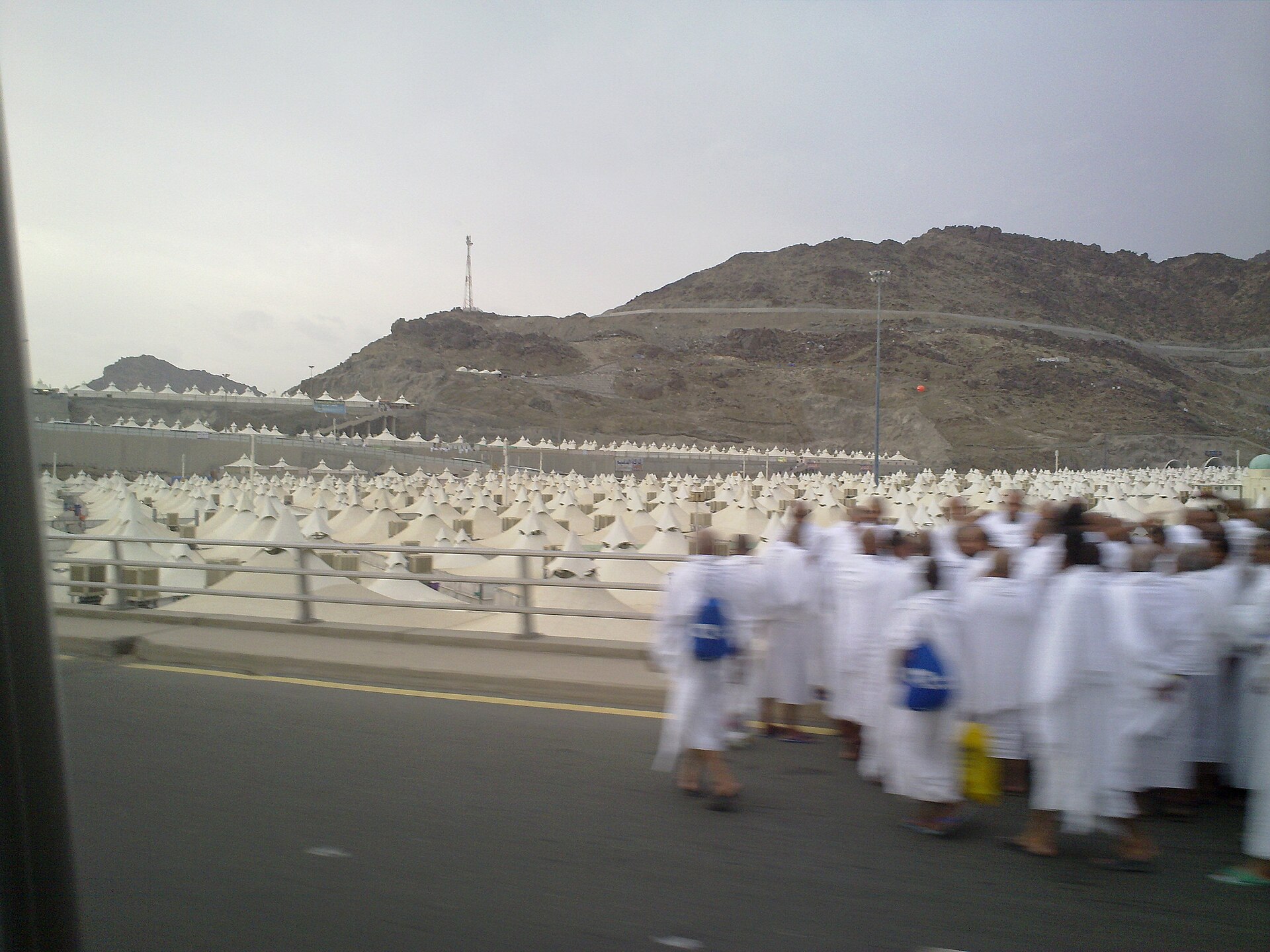 Hajj pilgrims in white ihram arriving at Mina tent city Saudi Arabia