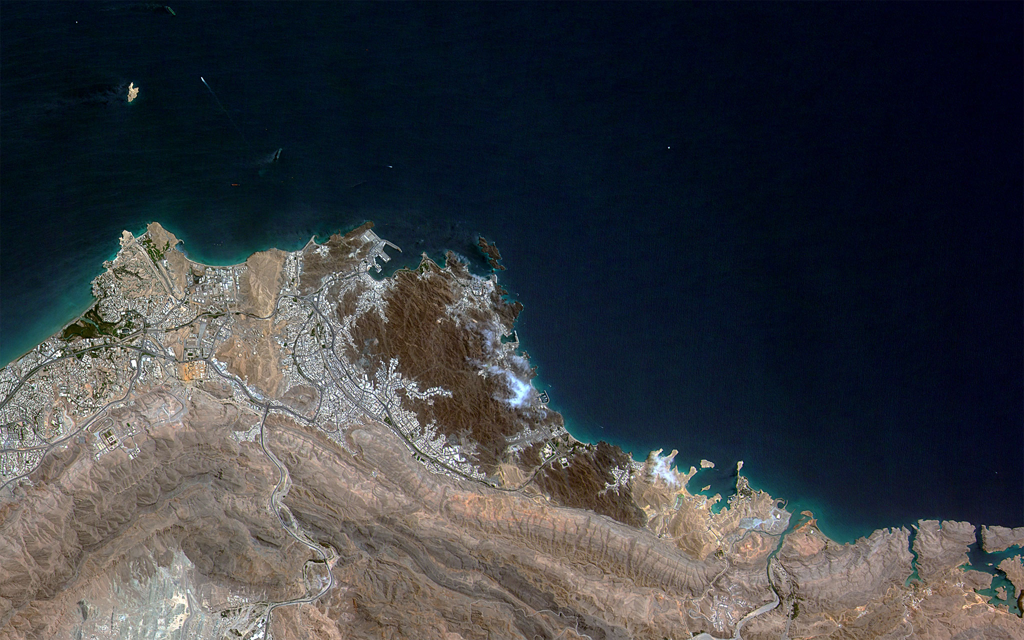 Satellite view of Muscat, Oman, showing the coastal capital city that hosts the back-channel between Washington and Tehran