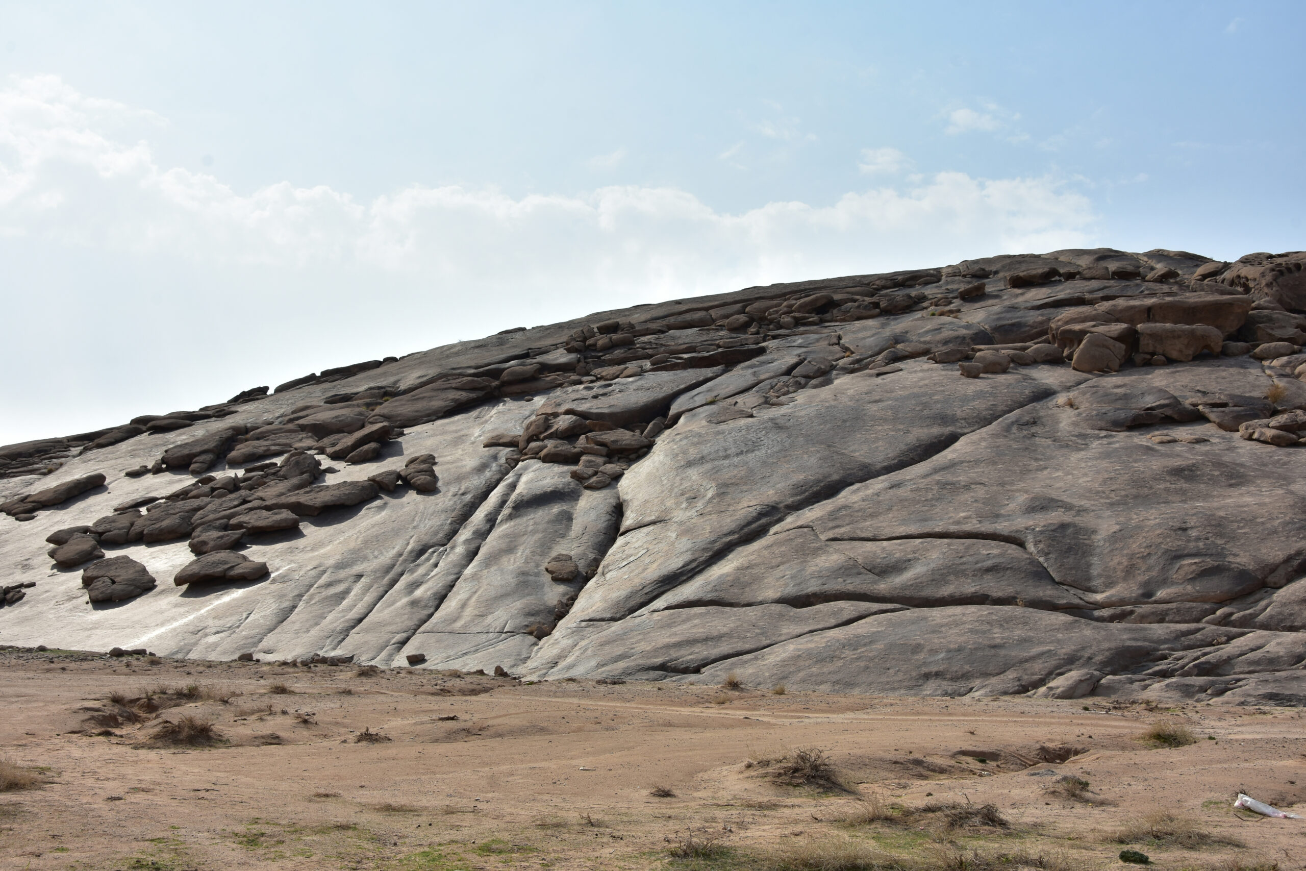 Large rock formation rising from the desert floor in the Najd region of central Saudi Arabia