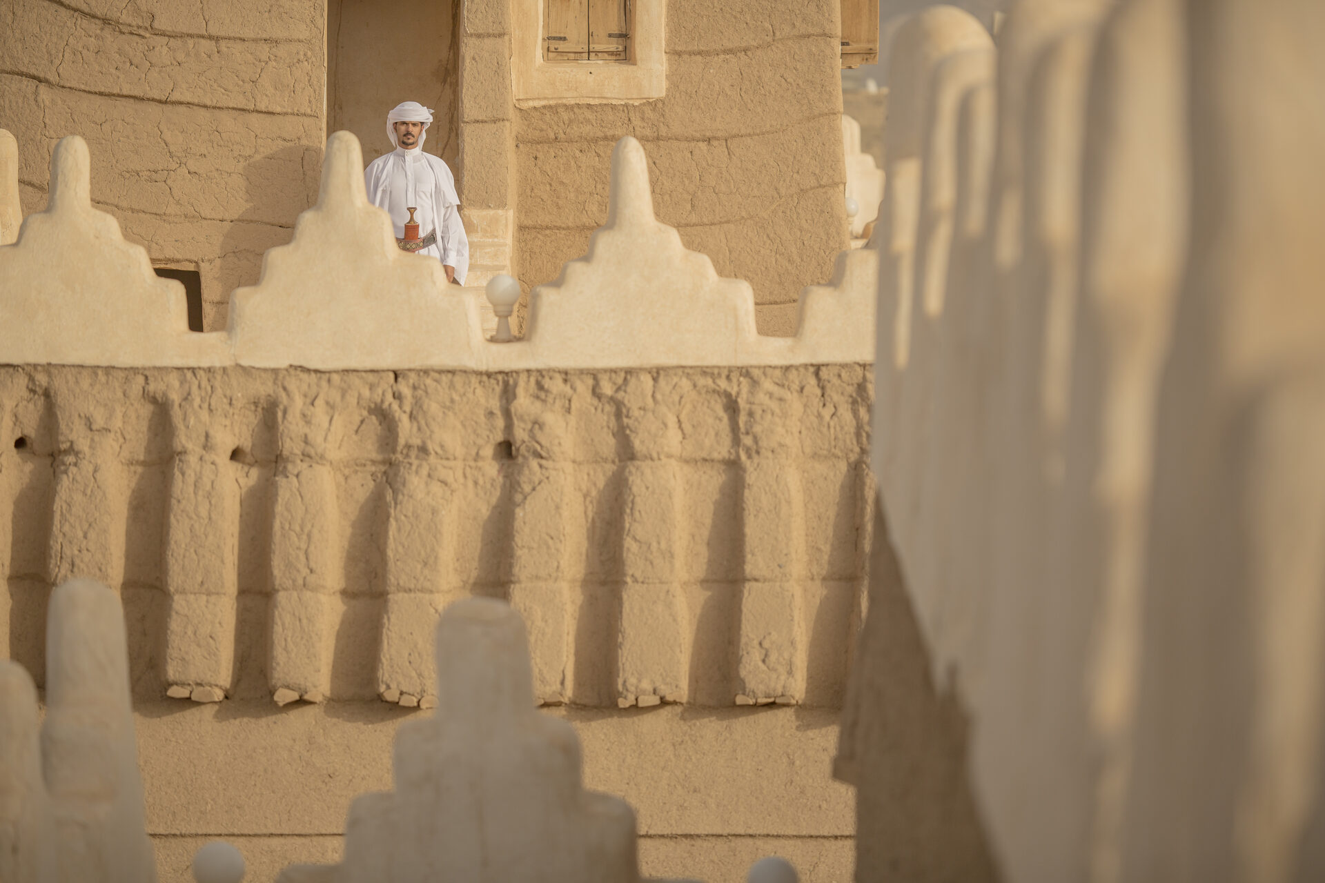 The ornate mud-brick battlements and decorative crenellations of Emara Palace in Najran