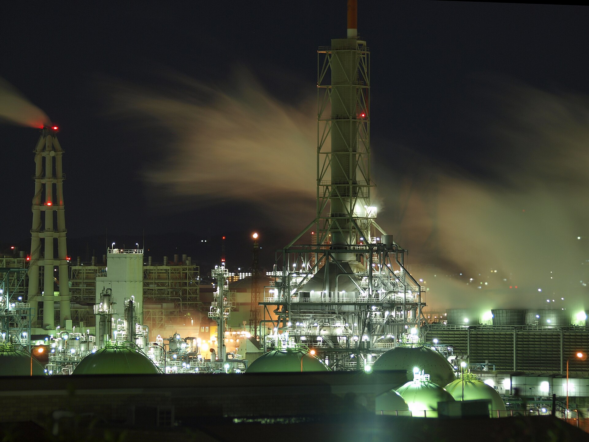 Negishi oil refinery in Yokohama Japan at night with distillation towers and spherical storage tanks