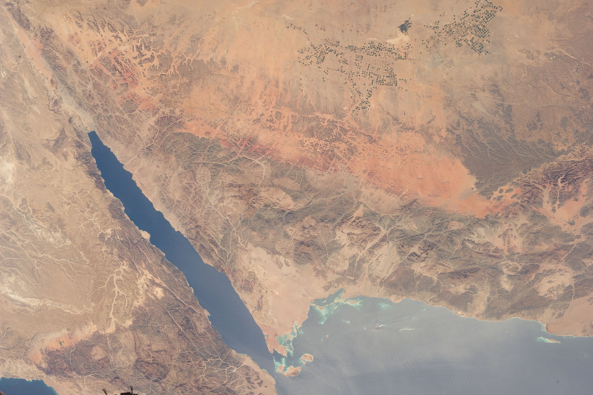 NASA ISS astronaut view of northwest Saudi Arabia showing the Tabuk region and Red Sea coastline — the terrain of the NEOM development corridor