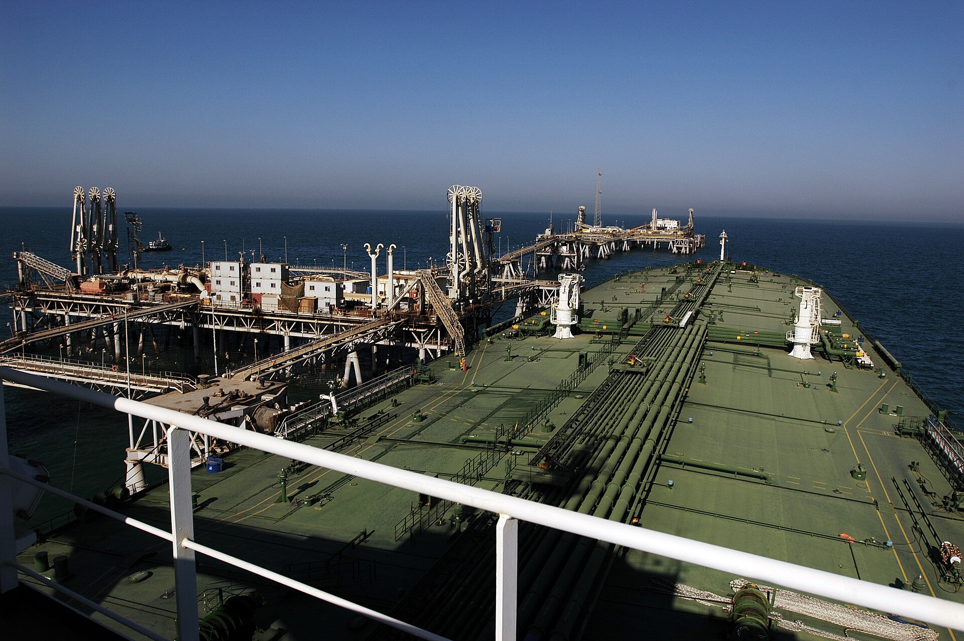 Oil tanker loading crude oil at the Al Basrah Oil Terminal in the Persian Gulf, with loading arms and offshore infrastructure visible