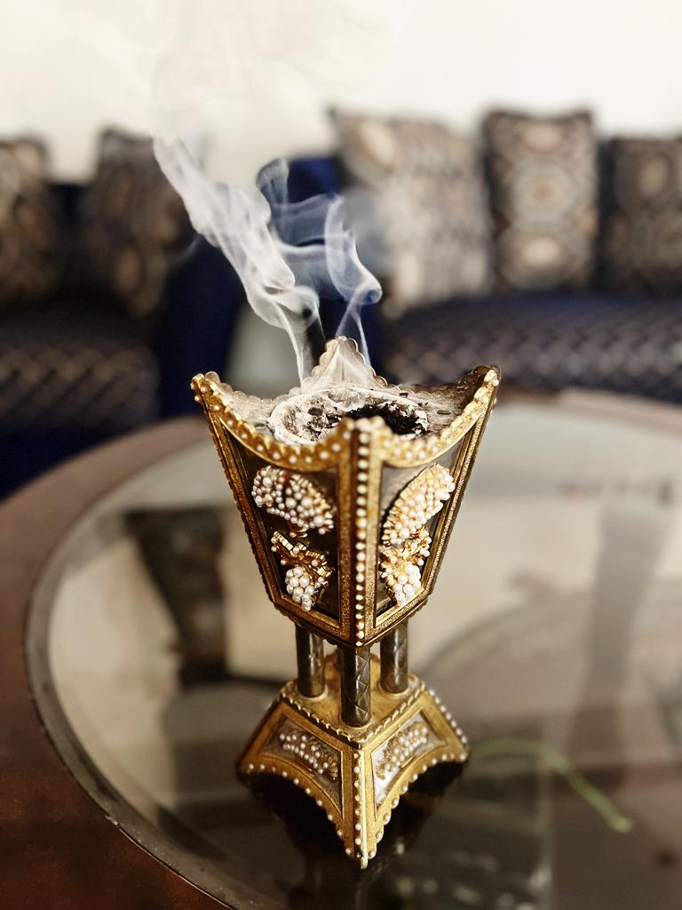 Traditional Arabian oud incense burner with smoke rising, a common purchase from Saudi night souqs