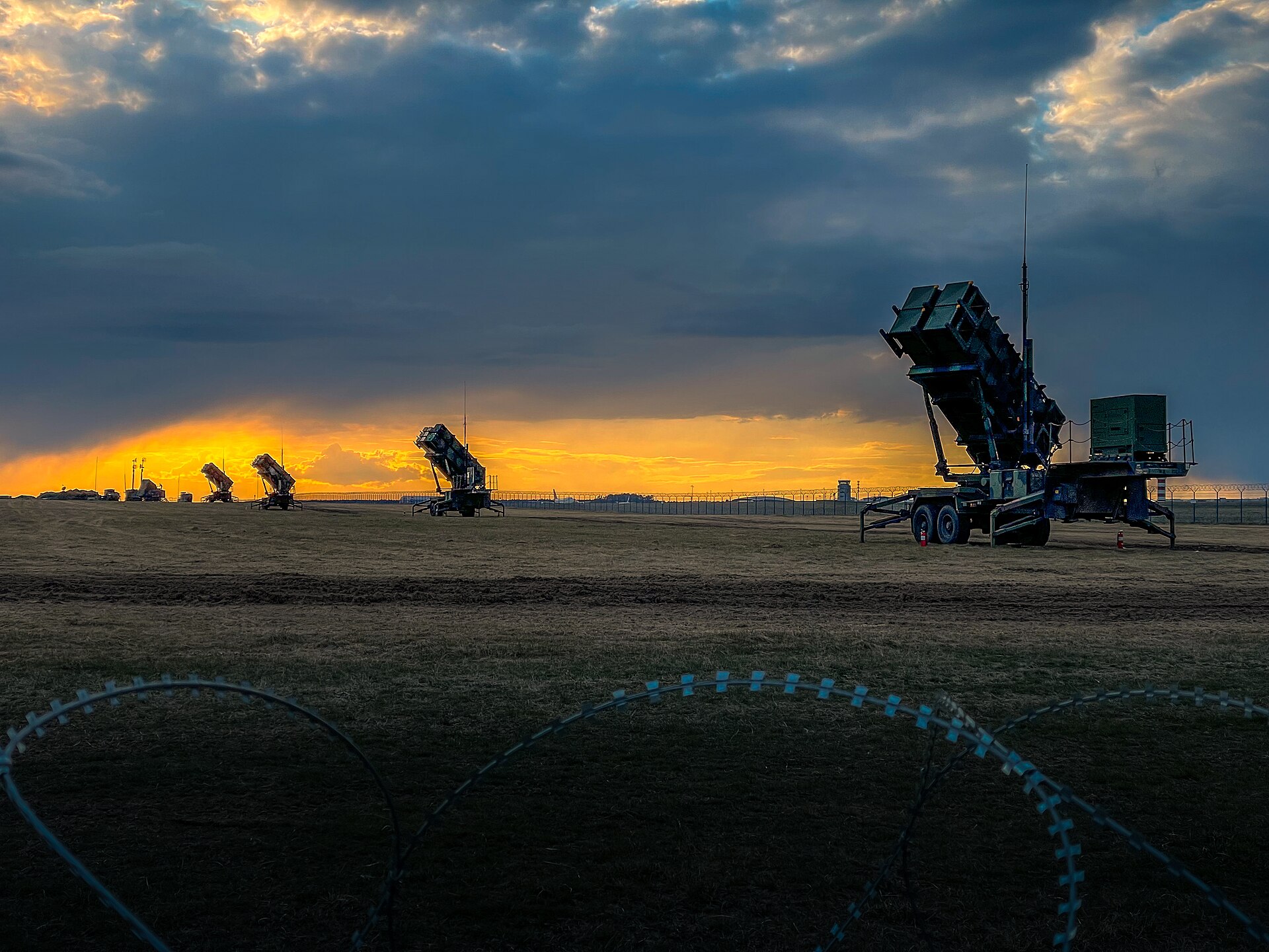 Multiple US Army Patriot missile launcher systems deployed at sunset in Poland, illustrating the air defense posture that Saudi Arabia operates around Prince Sultan Air Base