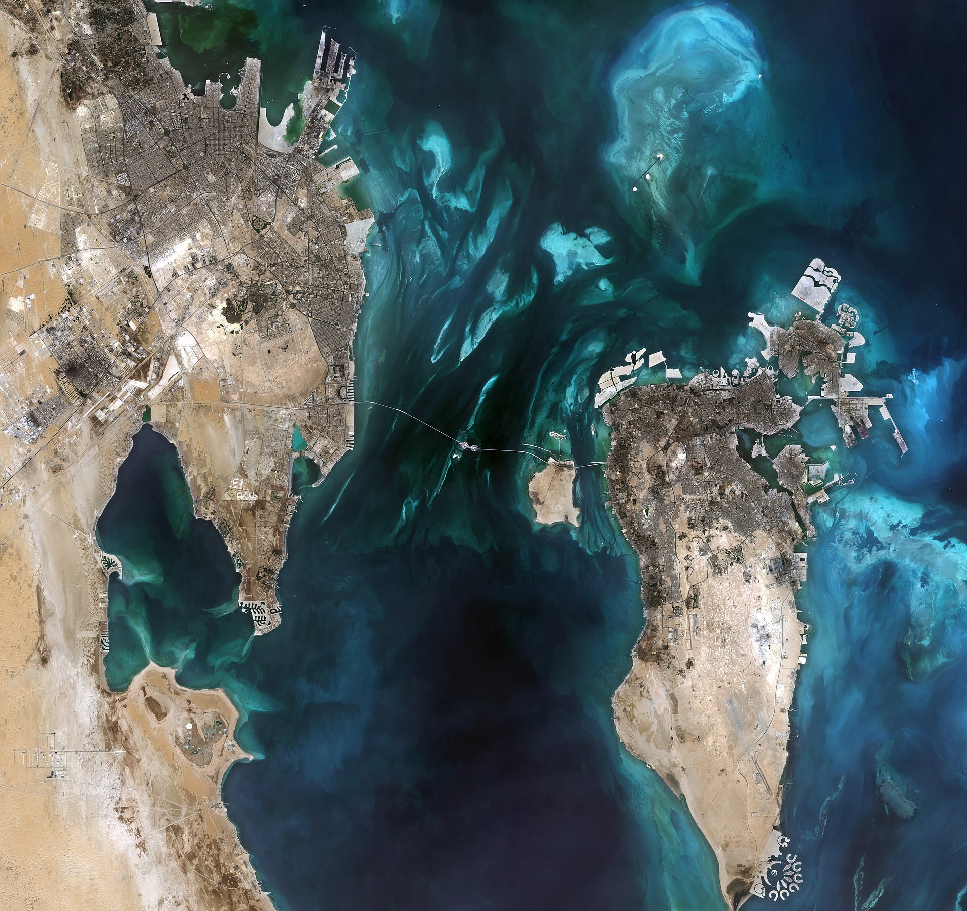 Sentinel-2 satellite image of the Persian Gulf showing Bahrain and eastern Saudi Arabia coastline, with the King Fahd Causeway visible, and the shallow teal waters characteristic of the Gulf that carry contamination along dominant current paths