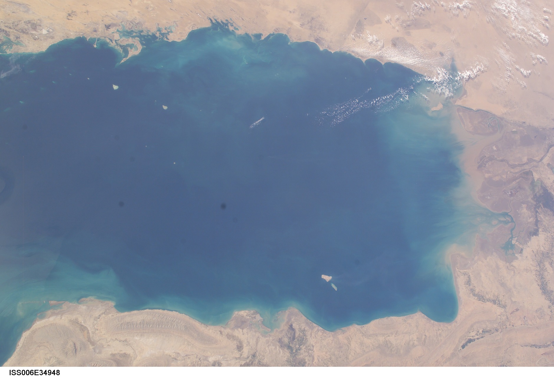 ISS orbital photograph of the Persian Gulf showing Iran to the north and Saudi Arabia and UAE to the south, with the Strait of Hormuz visible at right