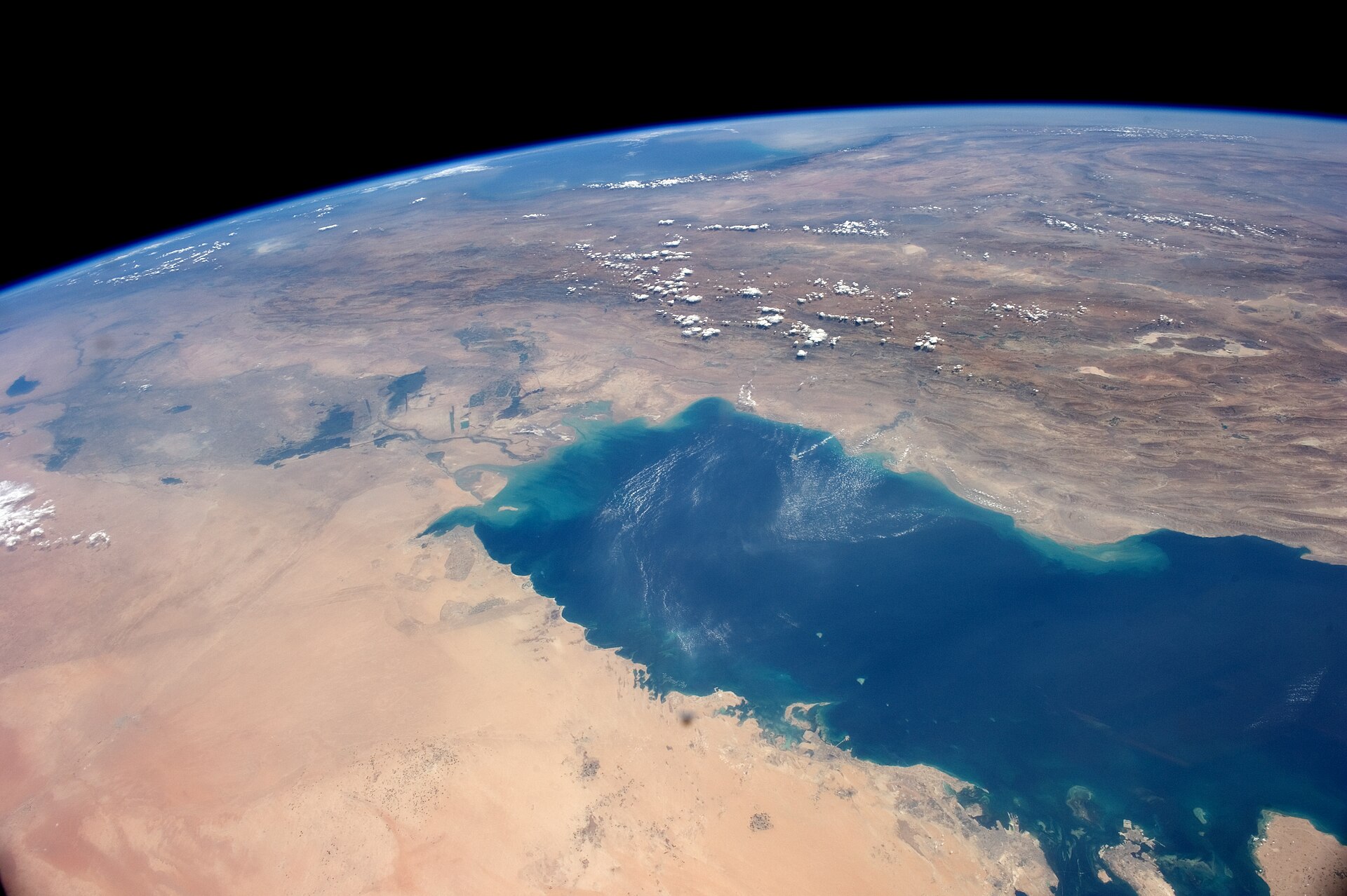 ISS astronaut view of the full Persian Gulf showing the Arabian Peninsula coast and Iranian shore, the 200-kilometre operational range separating UAE bases from Lavan Island