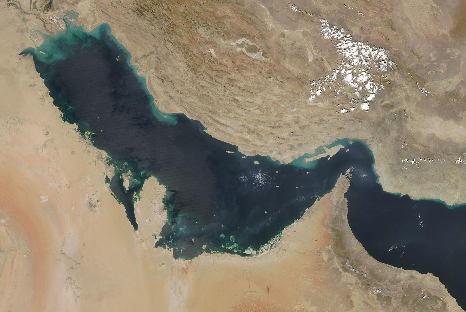 NASA MODIS satellite image of the Persian Gulf and Strait of Hormuz — the 21-mile-wide chokepoint through which roughly 20 percent of global oil supply transits