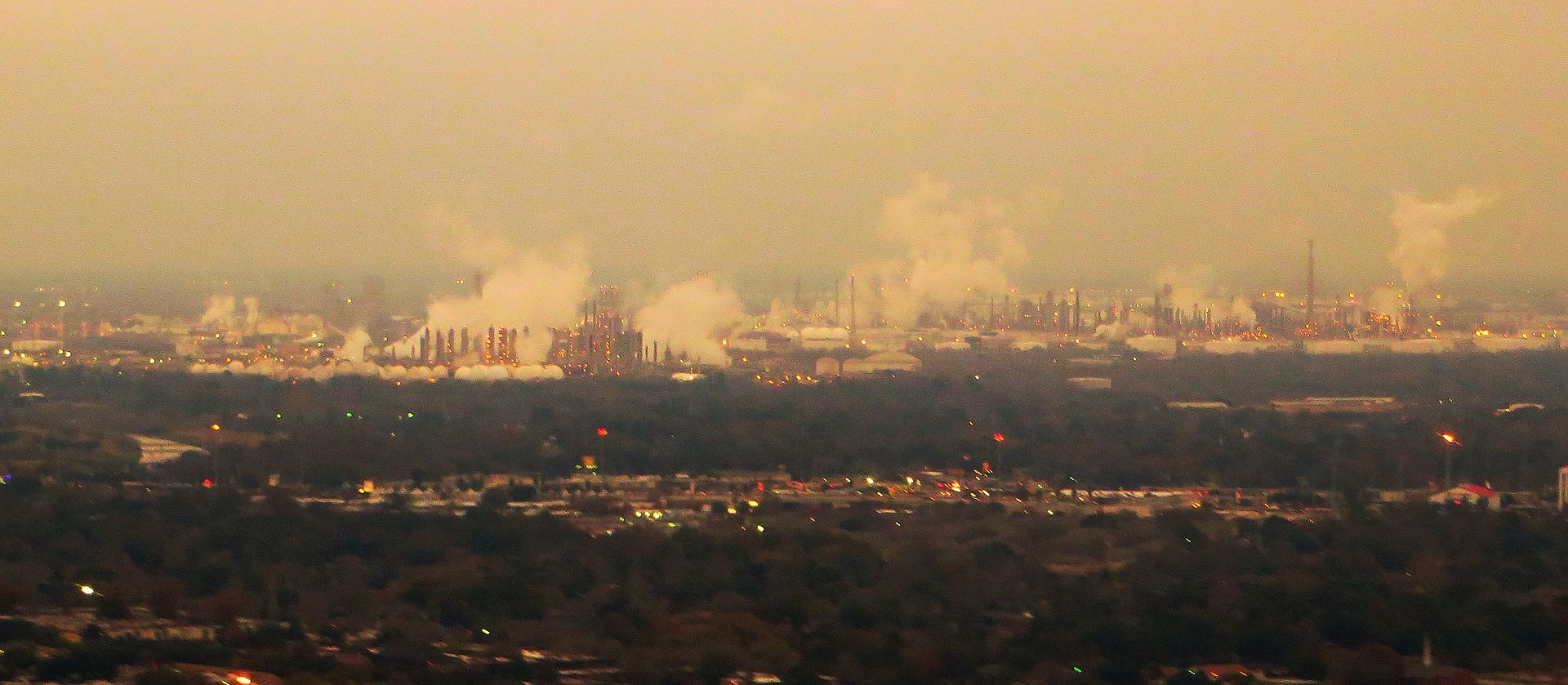 Large petrochemical refinery complex with multiple distillation towers, flare stacks and storage tanks, similar in scale to the SAMREF refinery at Yanbu