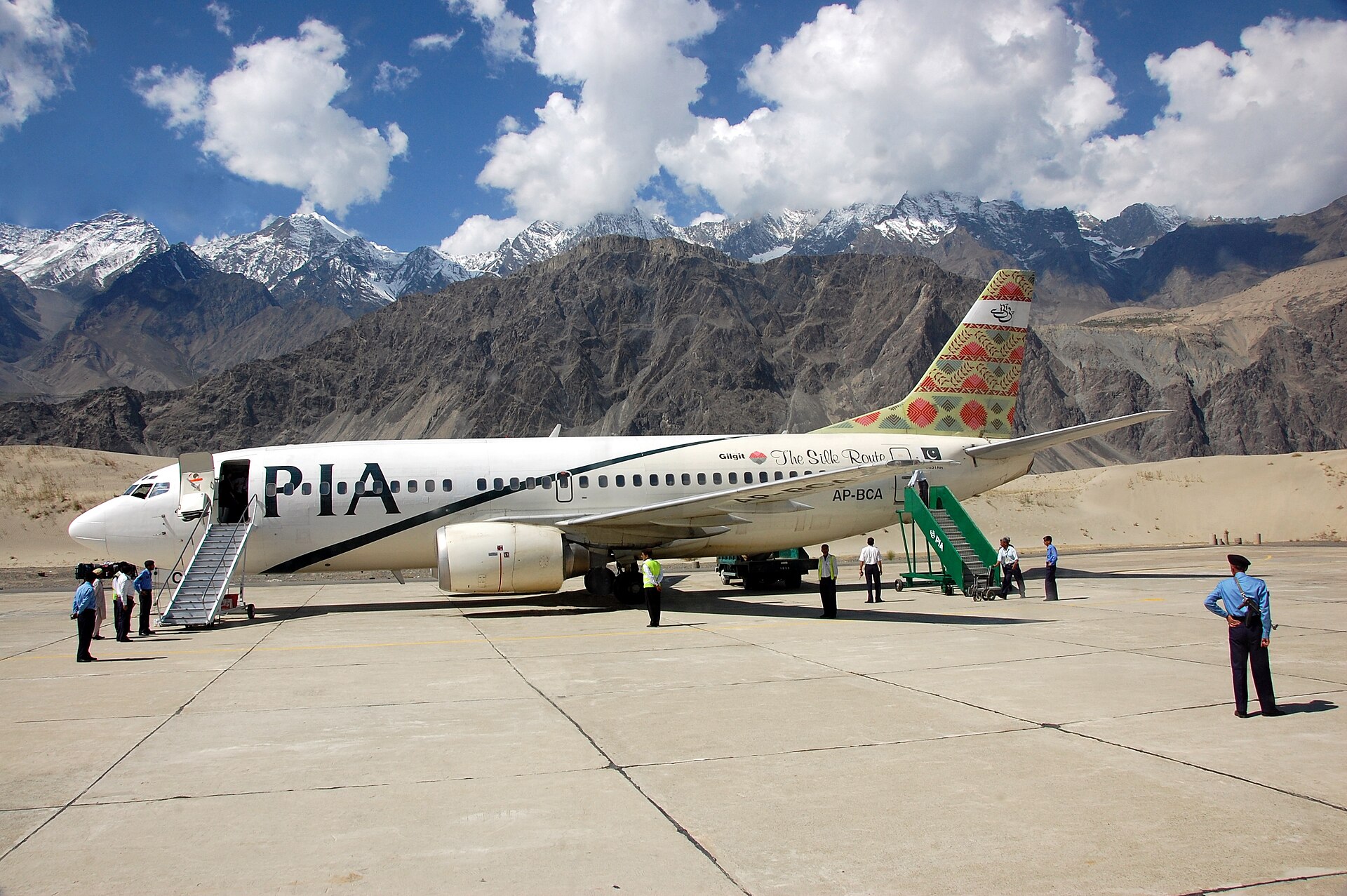 Pakistan International Airlines Boeing 737 aircraft on tarmac at Gilgit airport with ground crew and boarding stairs