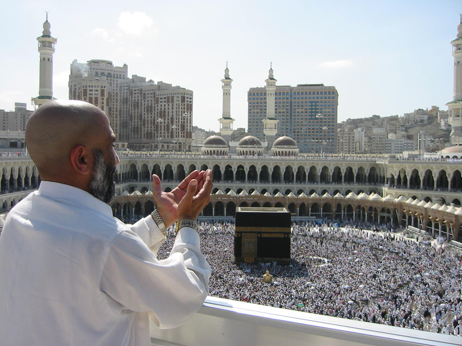 Pilgrim supplicating at Masjid Al Haram overlooking the Kaaba in Mecca